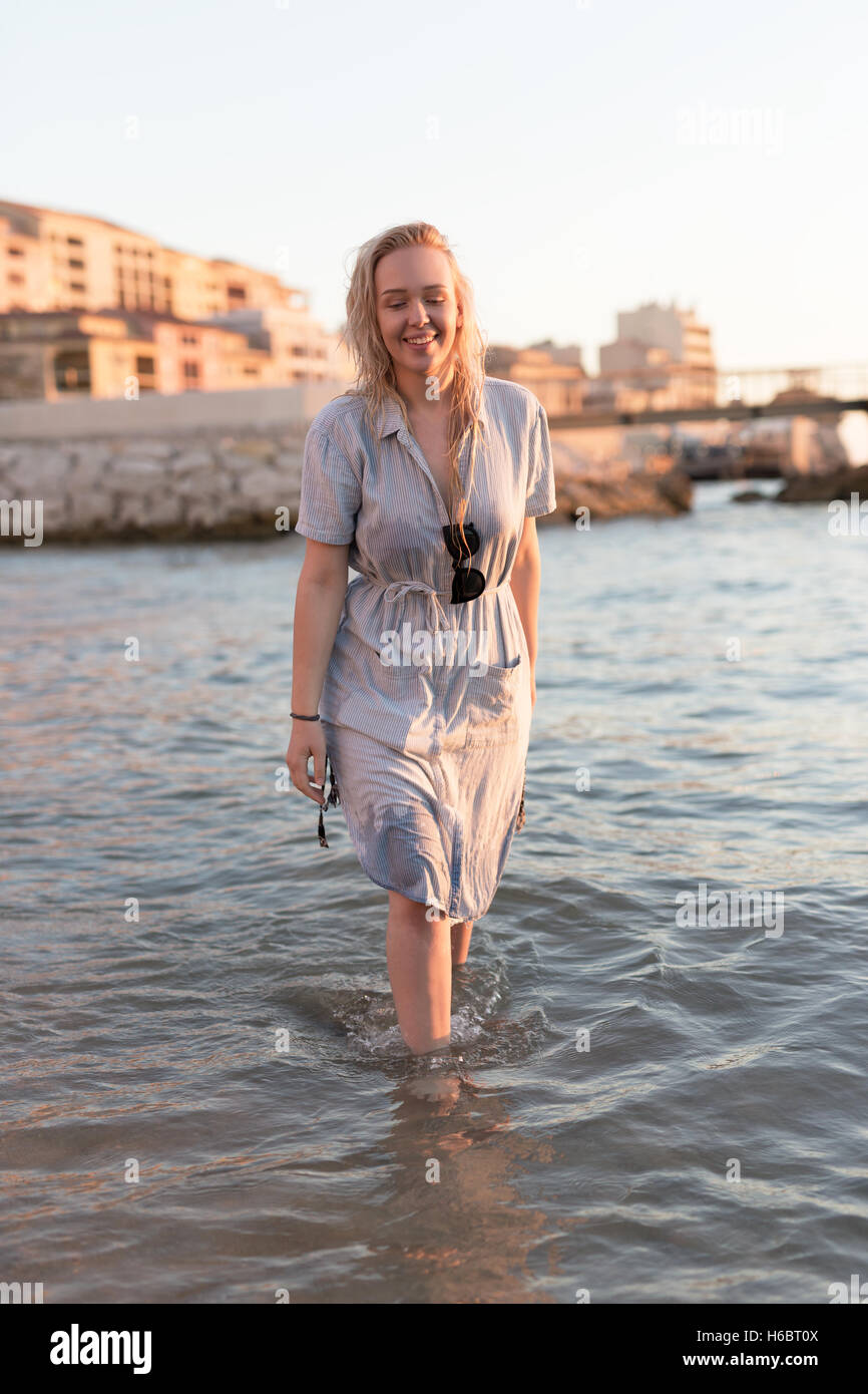 Young woman in dress walking on the beach Stock Photo - Alamy