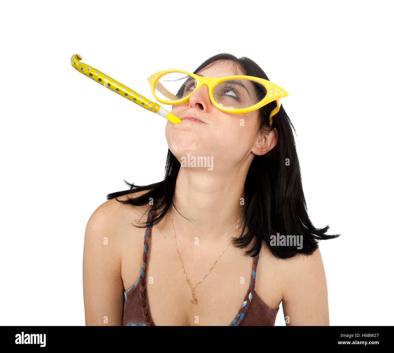 Head and shoulders view of an adult Caucasian black haired woman in her early 30's, wearing funky oversized spectacles and blowi Stock Photo