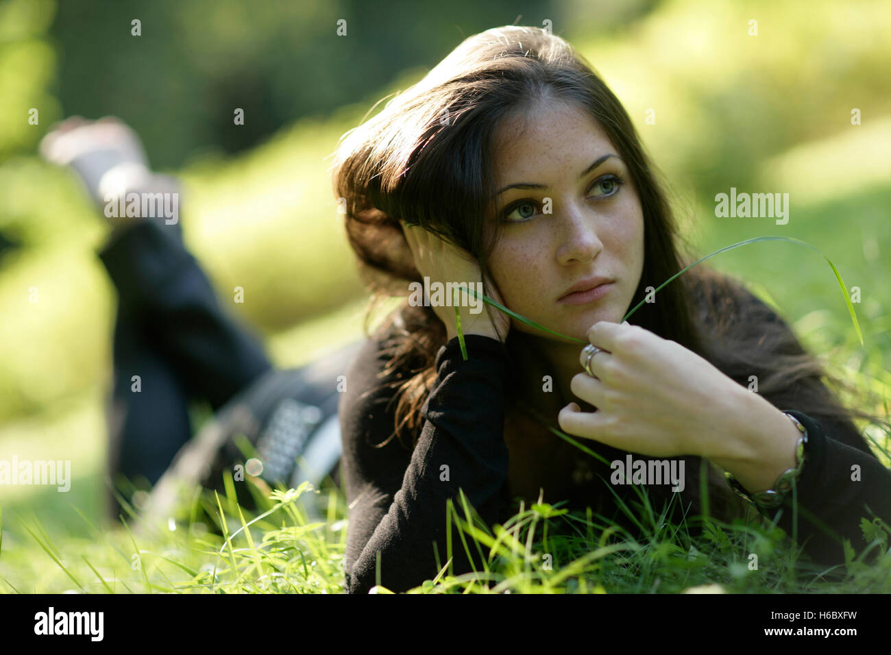 Young woman lying in the grass Stock Photo - Alamy