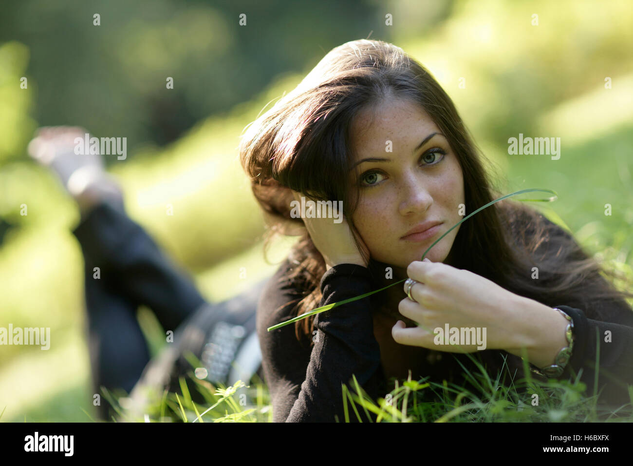 Young woman lying in the grass Stock Photo - Alamy