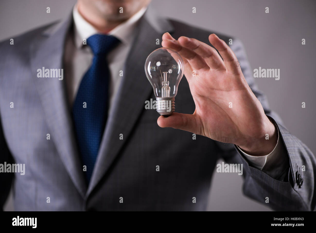 Businessman holding light bulb in creativity concept Stock Photo - Alamy