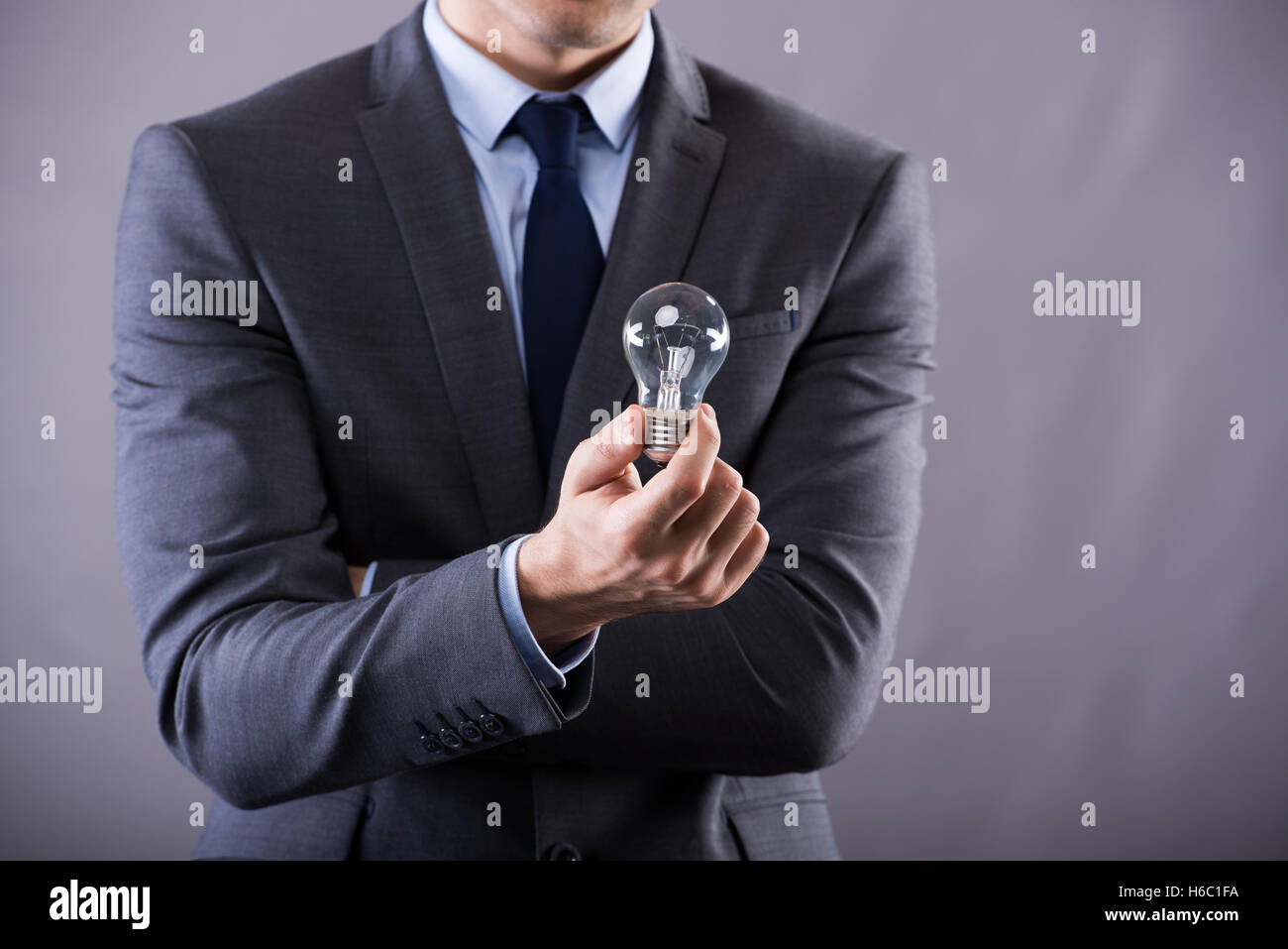 Businessman holding light bulb in creativity concept Stock Photo - Alamy