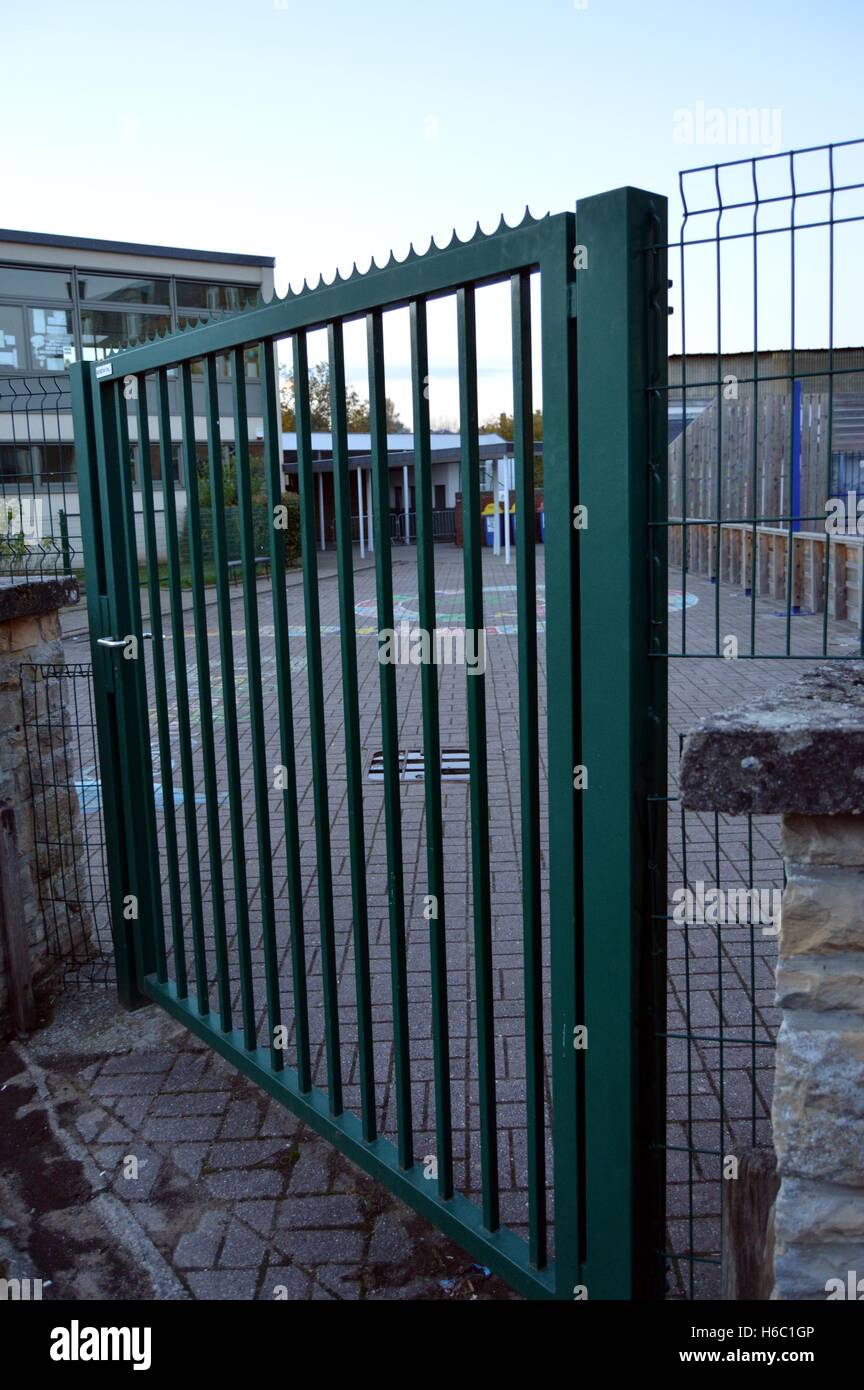 Metal railing of green color which closes enters him of a school Stock Photo