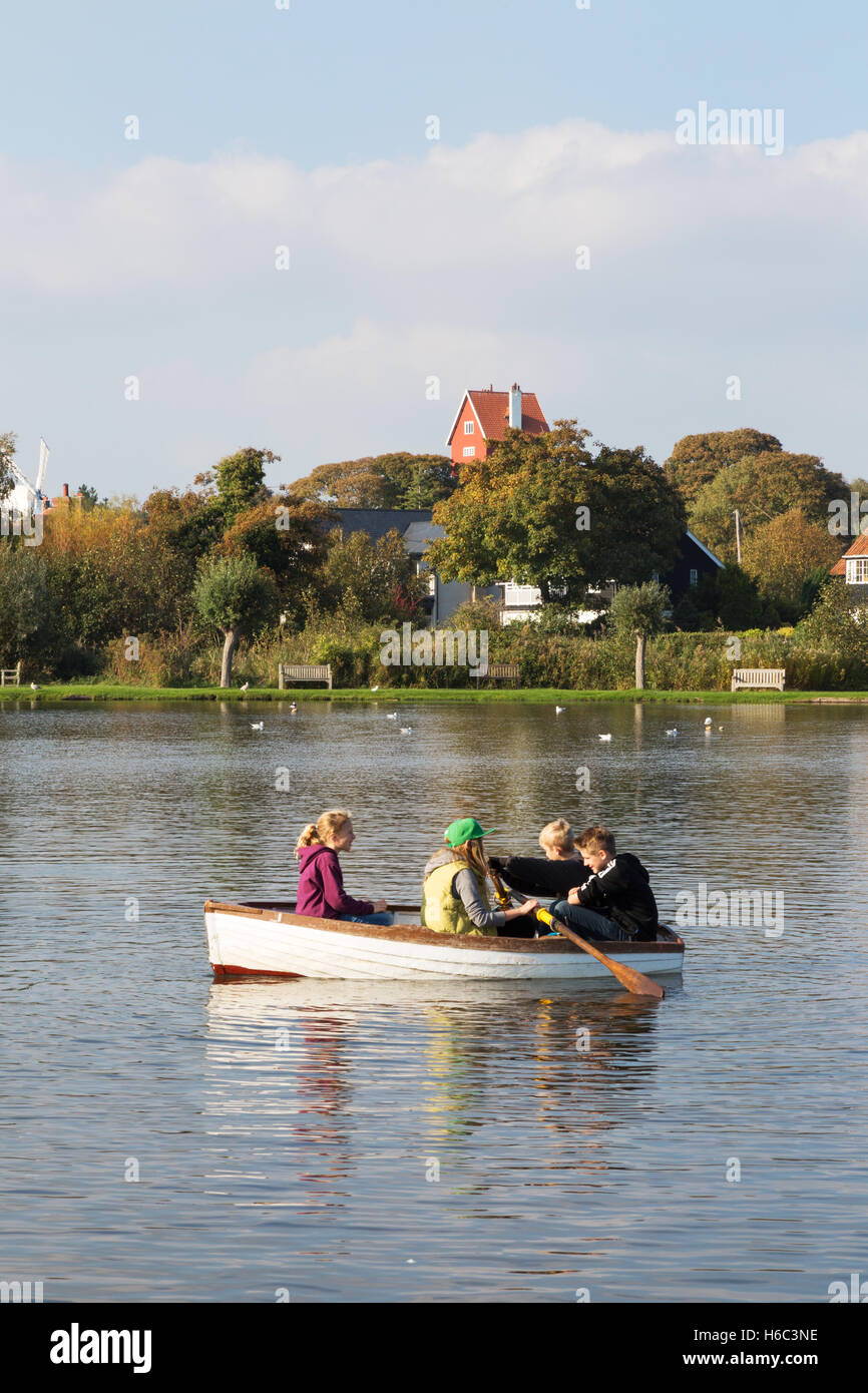 Teenagers in a rowing boat on Thorpeness Meare, Thorpeness Village, Suffolk coast, East Anglia, England UK Stock Photo