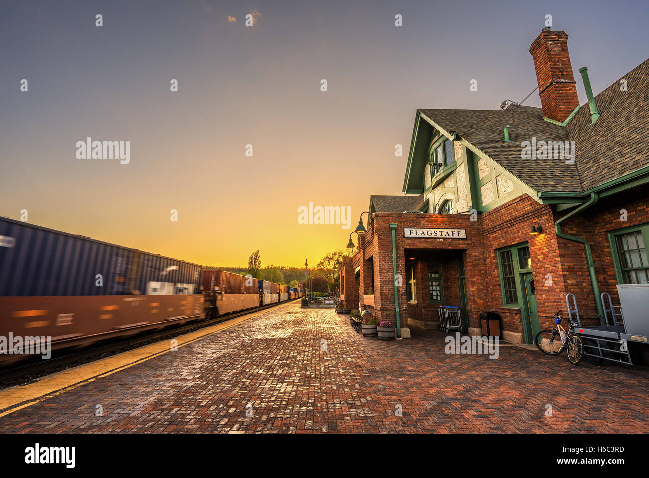 Amtrak Train going through the historic train station in Flagstaff at sunset. This station is located on the historic Route 66. Stock Photo