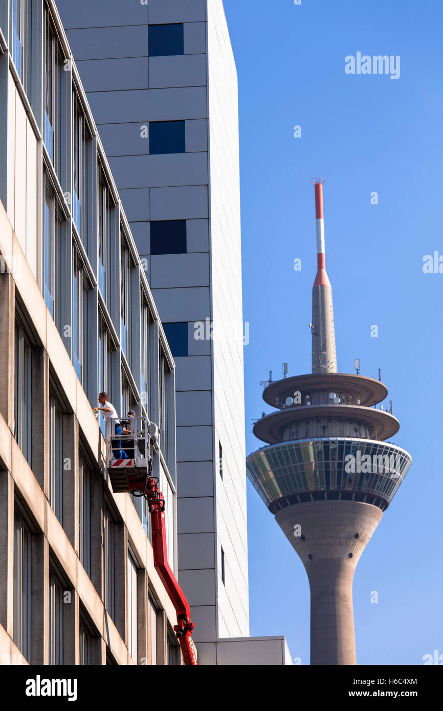 Germany, Duesseldorf, the television tower,  window cleaners at an office building at the Medienhafen (Media harbour). Stock Photo