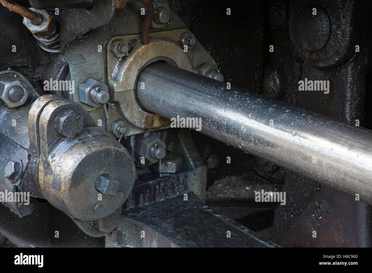 Heavy metal machinery. Piston on an old steam train. Oily closeup of the moving parts. Stock Photo
