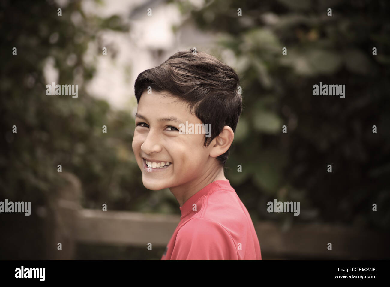 Portrait of young smiling boy - taken with vintage German lens.  Desaturated with added vignetting Stock Photo