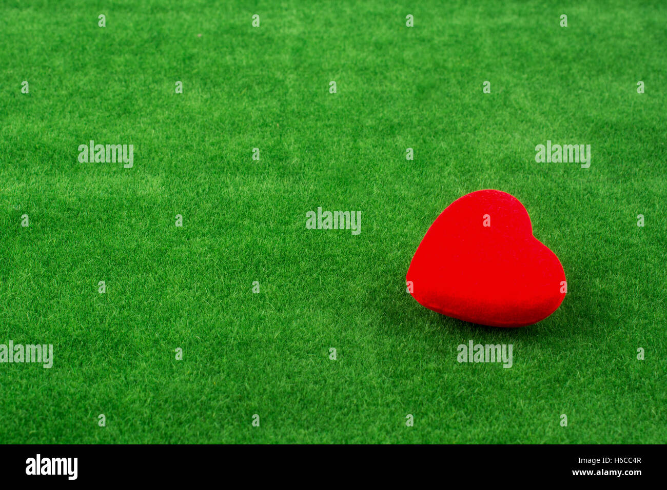 Red heart shape icon on fake green grass Stock Photo