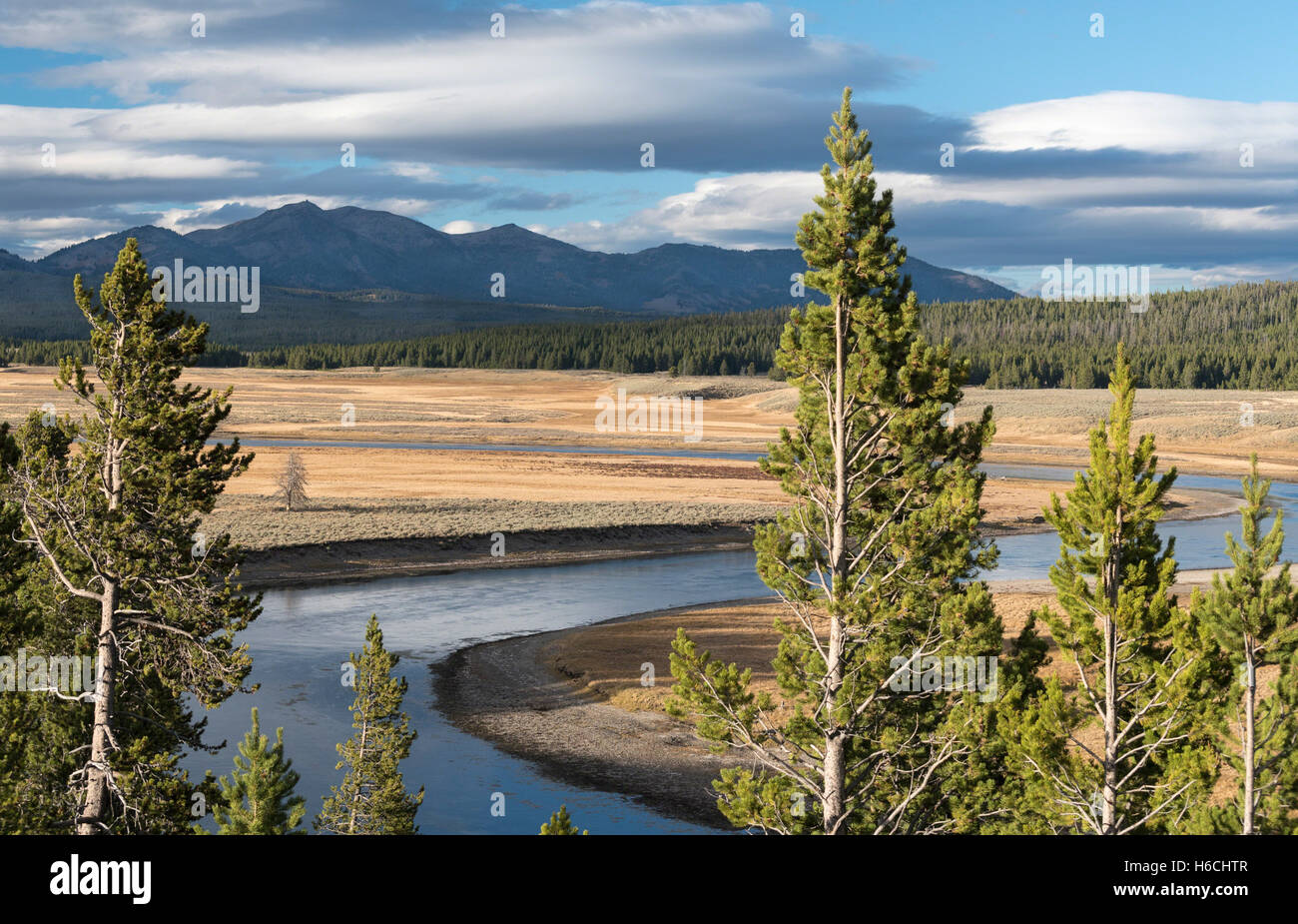 Storm clouds hover above Hayden Valley, Mt. Washburn, and the Yellowstone River  at sunset in Yellowstone National Park. Stock Photo