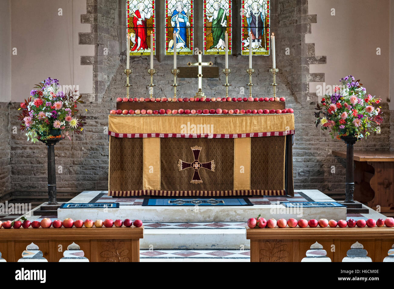 Clungunford, Shropshire, UK. Harvest Festival flower display with apples decorating the altar in St Cuthbert's Church Stock Photo