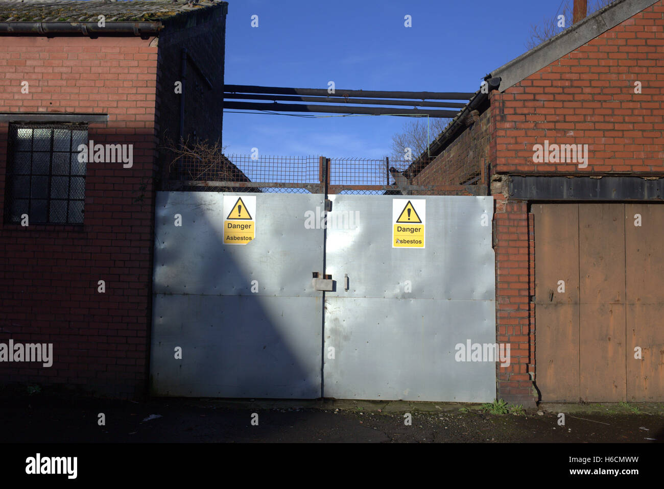 old factories closed by asbestos with signs and security Stock Photo