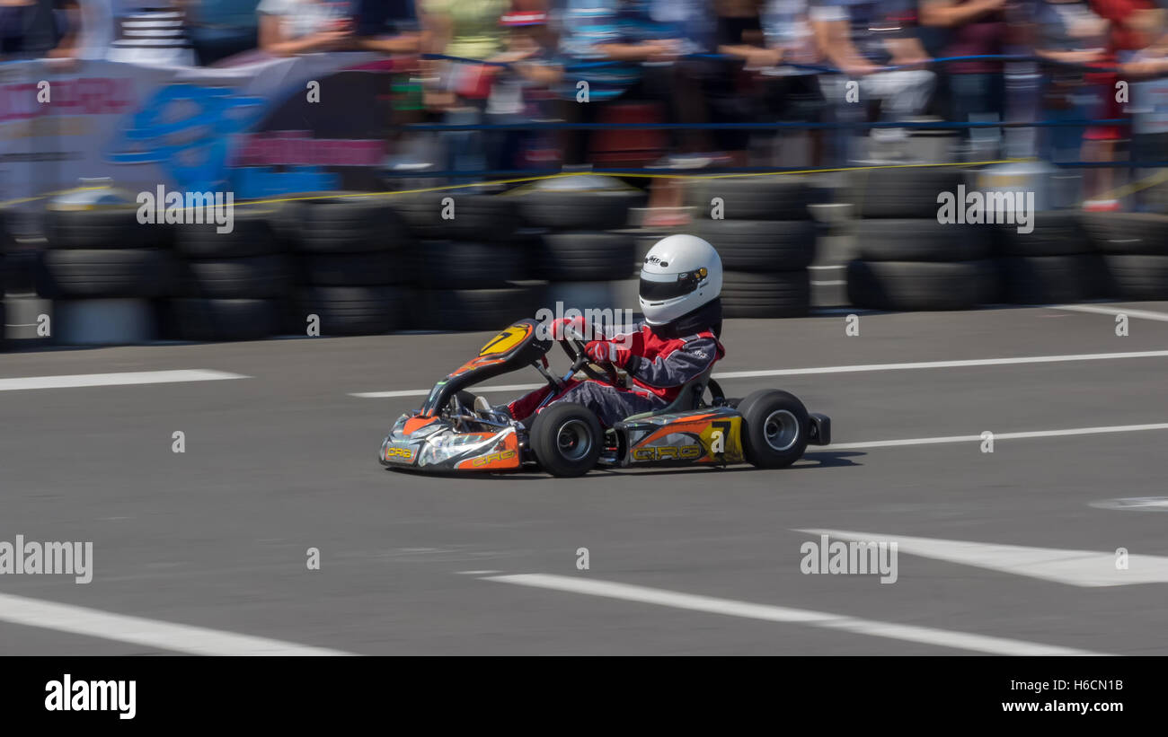 GALATI, ROMANIA - September 11, 2016: Boy drive karting car on a track to demonstrate the spectators the speed. Panning view Stock Photo