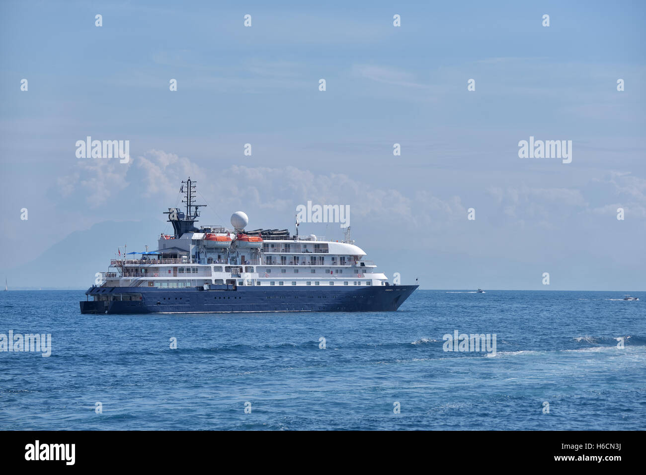 Small cruise ship on sea leaving the shore Stock Photo