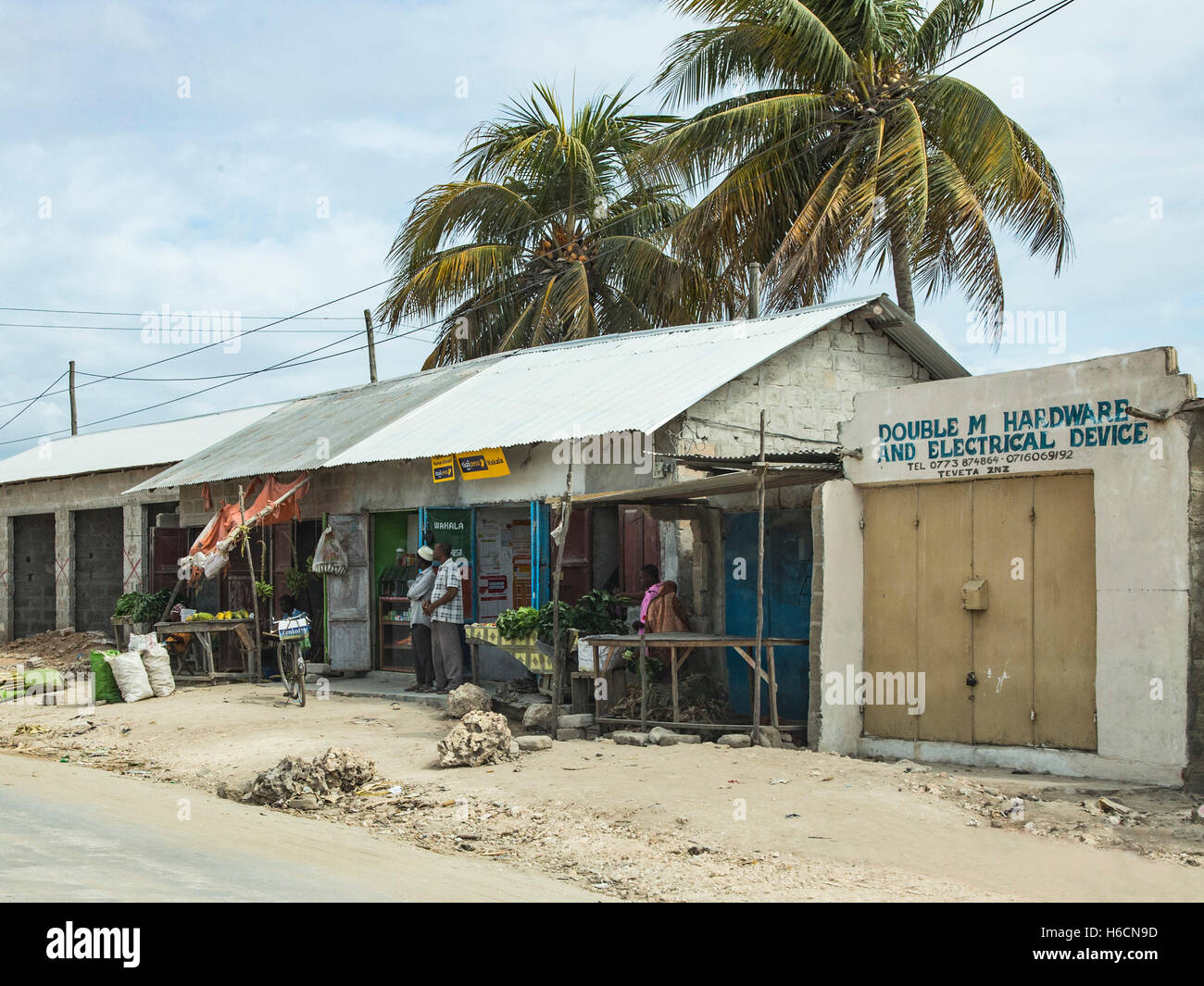A row of shops selling fruit, hardware , and electrical goods on