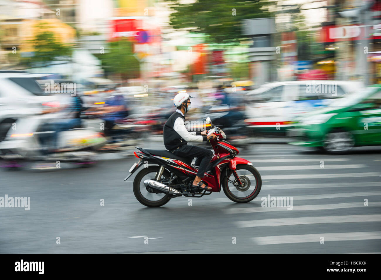 Scooter driver in heavy traffic, motion blur, Ho Chi Minh City, Vietnam Stock Photo