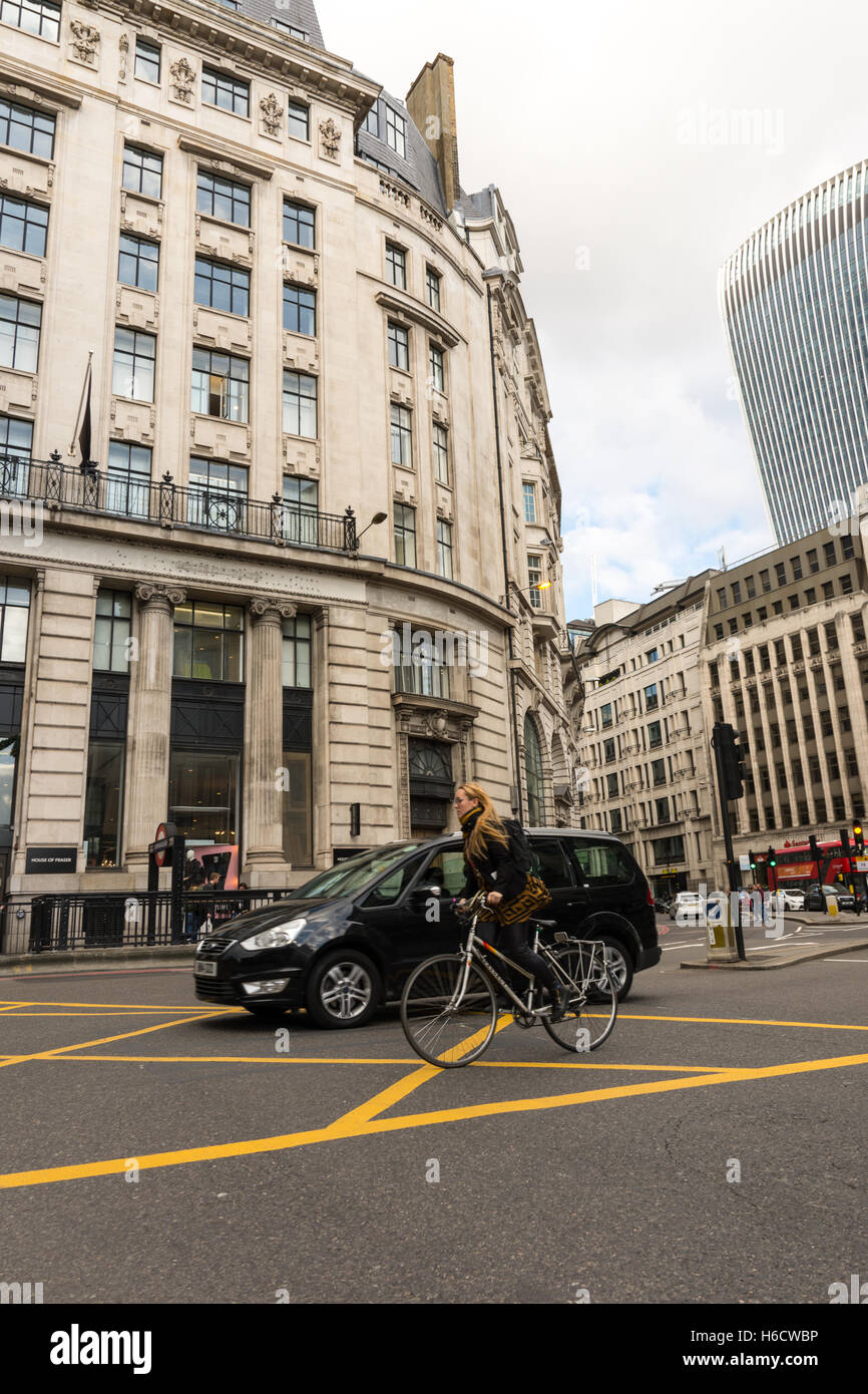 Cycling and driving in the City of London with typical London architecture in the background. Stock Photo