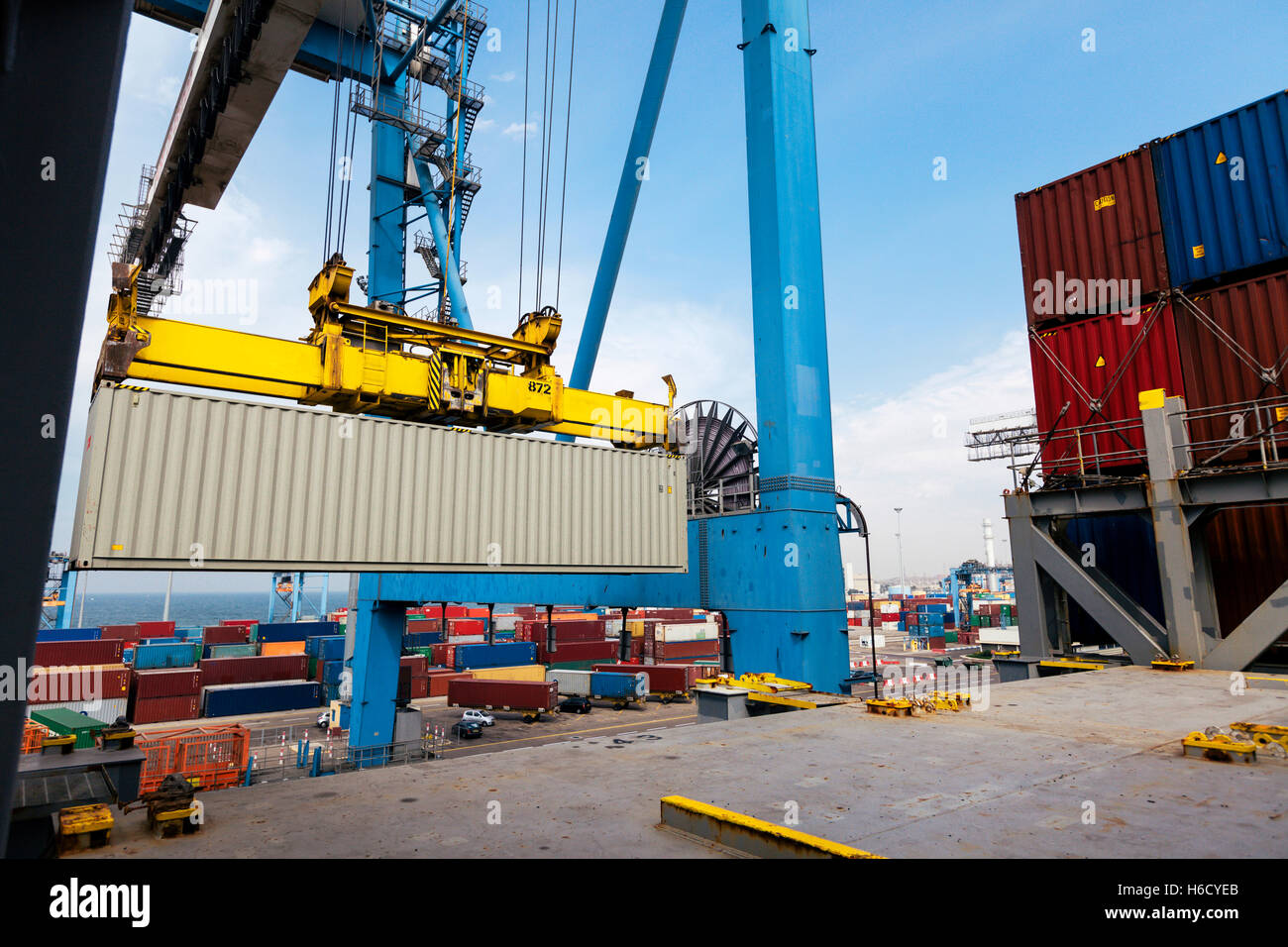 View of a container being loaded by a crane onto a freighter at a ...