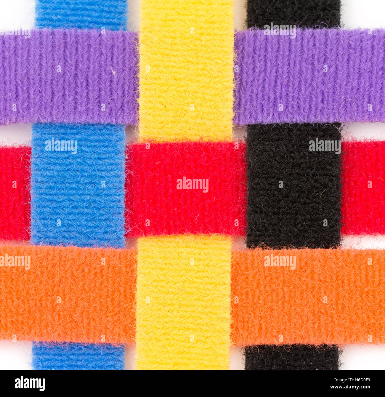 Colorful velcro strips braided together in over one, under one sequence, on white Stock Photo