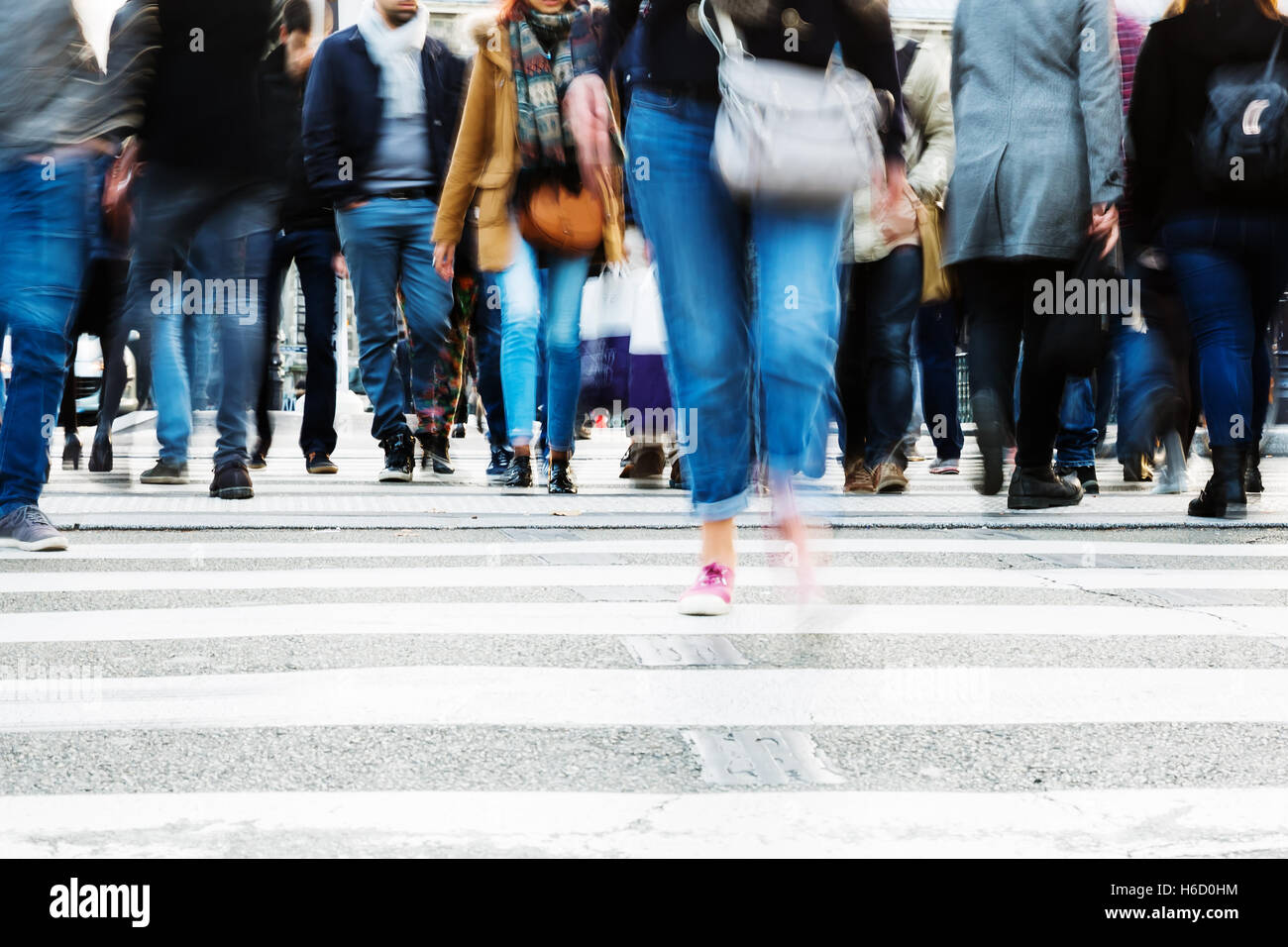 picture with motion blur of a crowd of people crossing a city street at ...