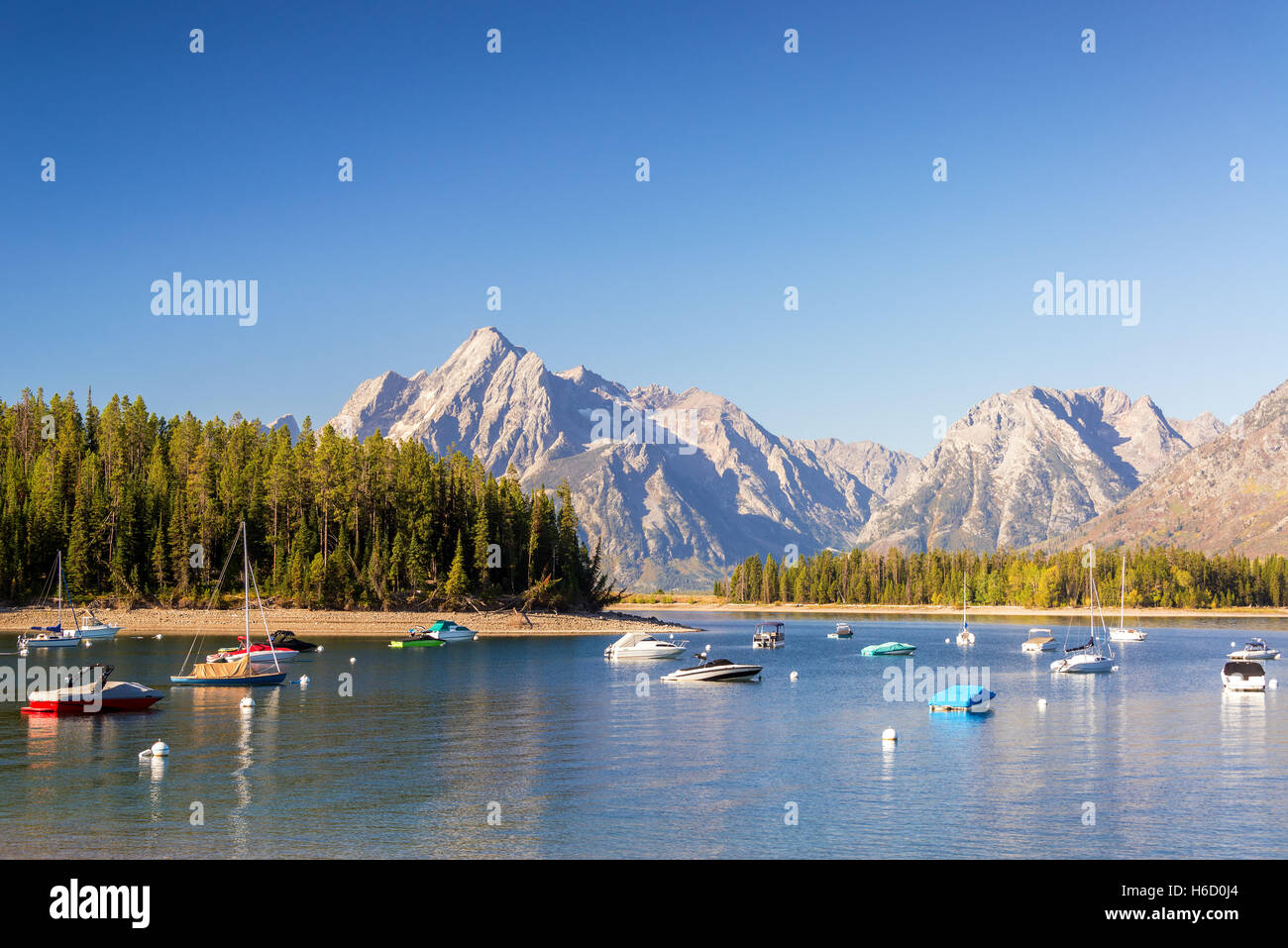 Boats in Colter Bay with the Teton Mountain Range in the background in Ground Teton National Park Stock Photo