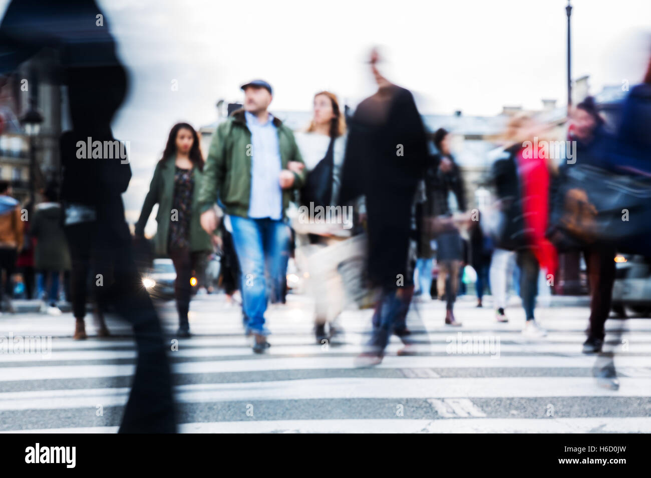 picture with motion blur of a crowd of people crossing a city street at ...