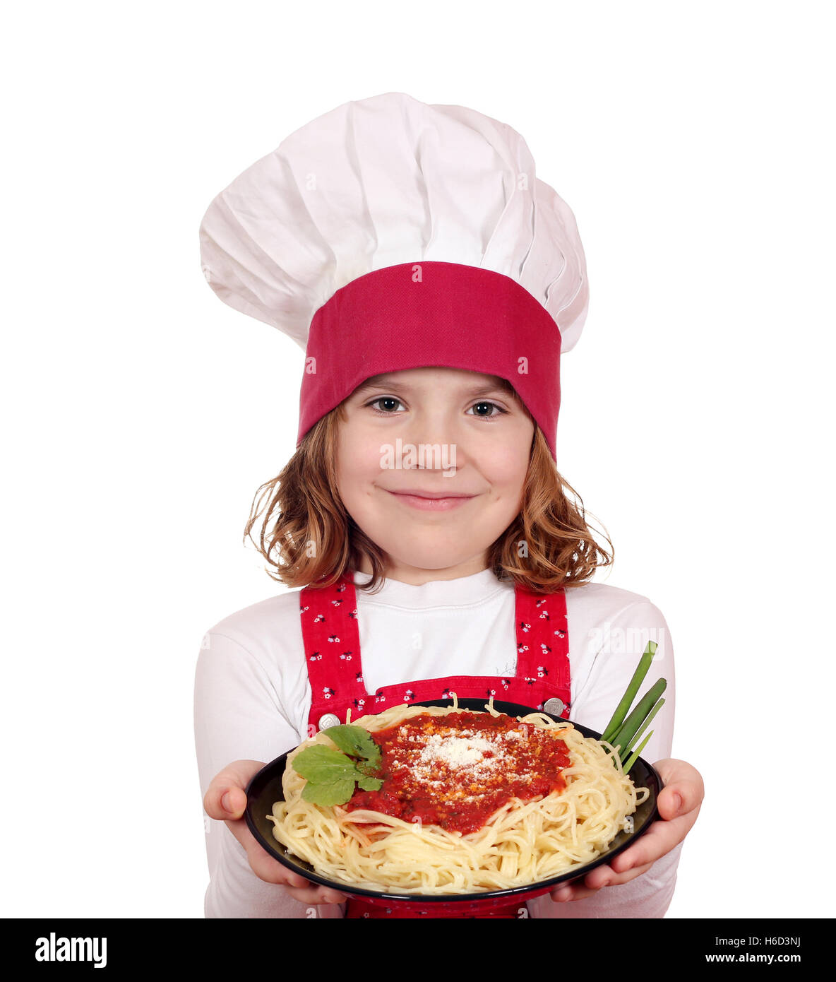 beautiful little girl cook hold dish with spaghetti Stock Photo