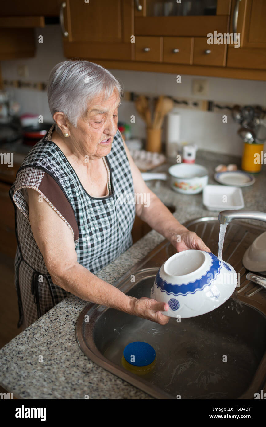 Мама моет бабушку. Бабушка моет посуду. Пожилая женщина на кухне. Пожилая женщина моет посуду. Бабушка мыла посуду.