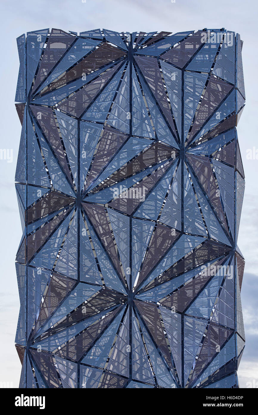 Close up view of sculptural chimney flue with faceted perforated panels. Dusk skies. Greenwich Energy Centre / The Optic Cloak, Stock Photo