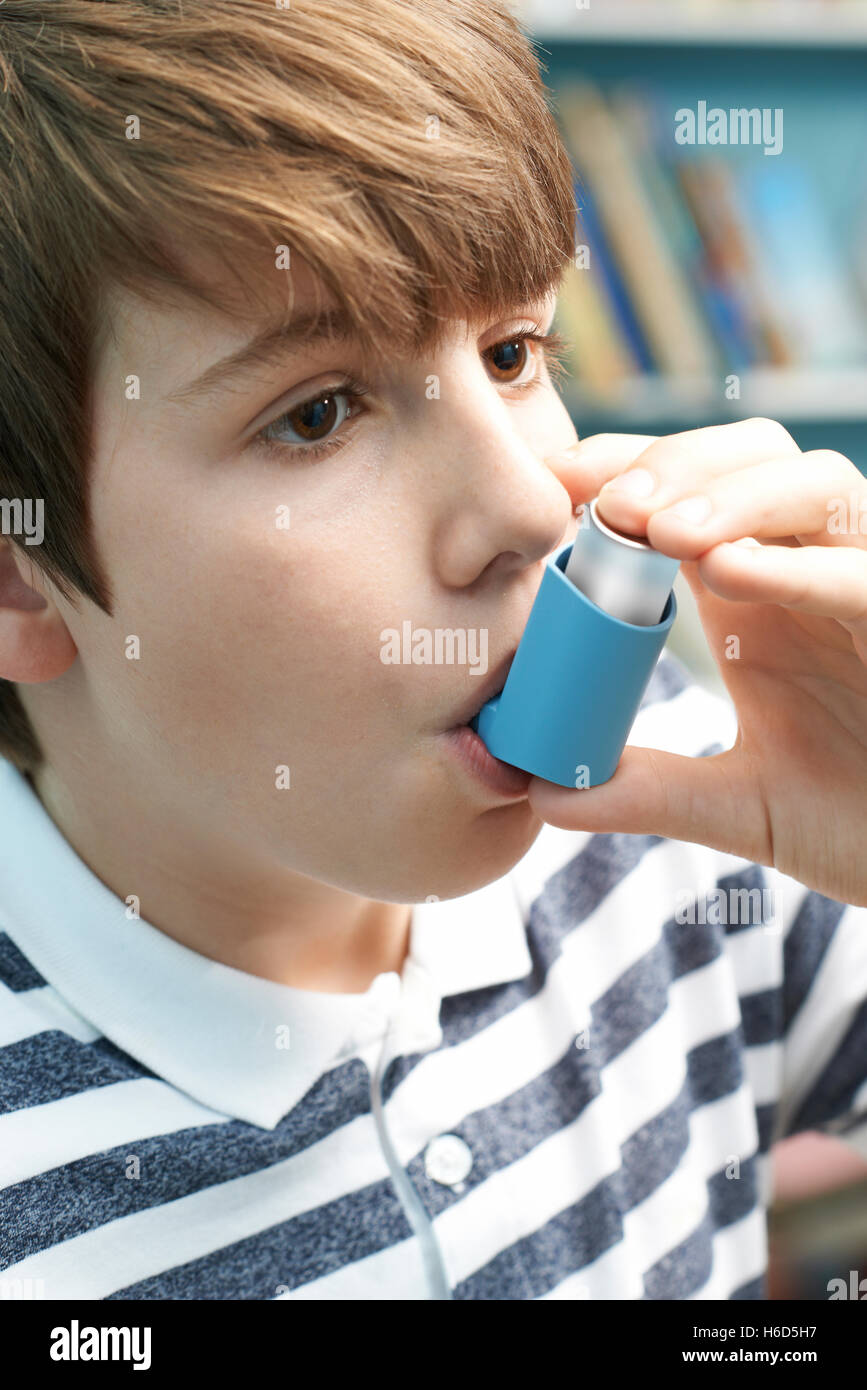Boy Using Inhaler To Treat Asthma Attack Stock Photo