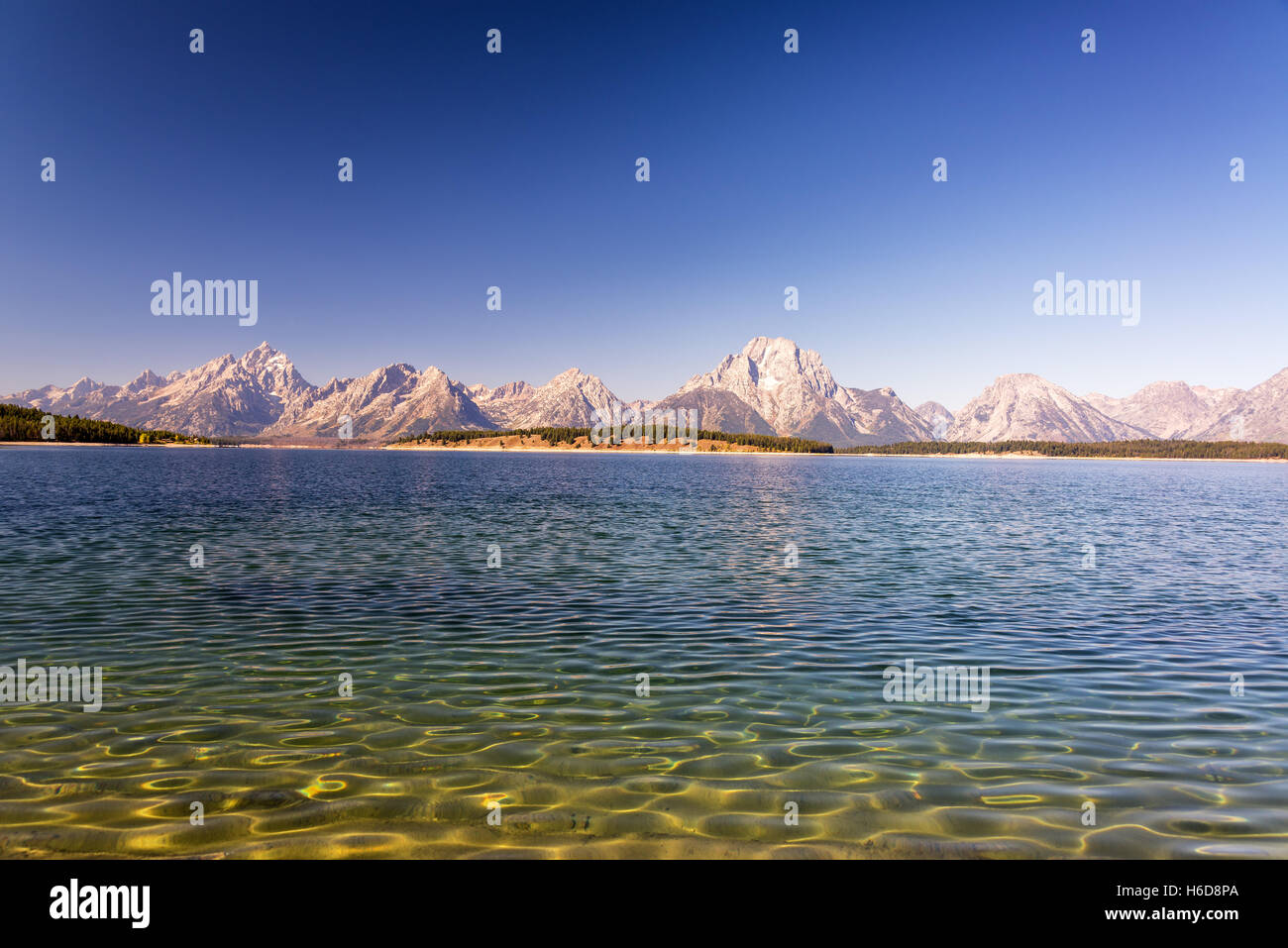 Ripples in Jackson Lake with the Teton Range in the background in Grand Teton National Park Stock Photo