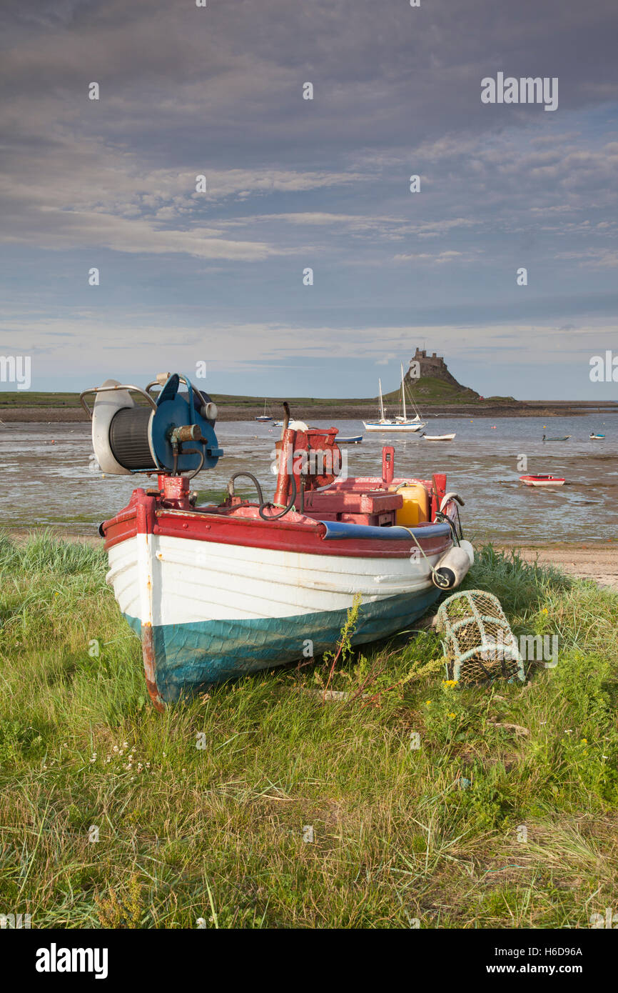 Traditional Coble fishing boats with a view to Lindisfarne Castle, Holy Island, Northumberland, UK Stock Photo