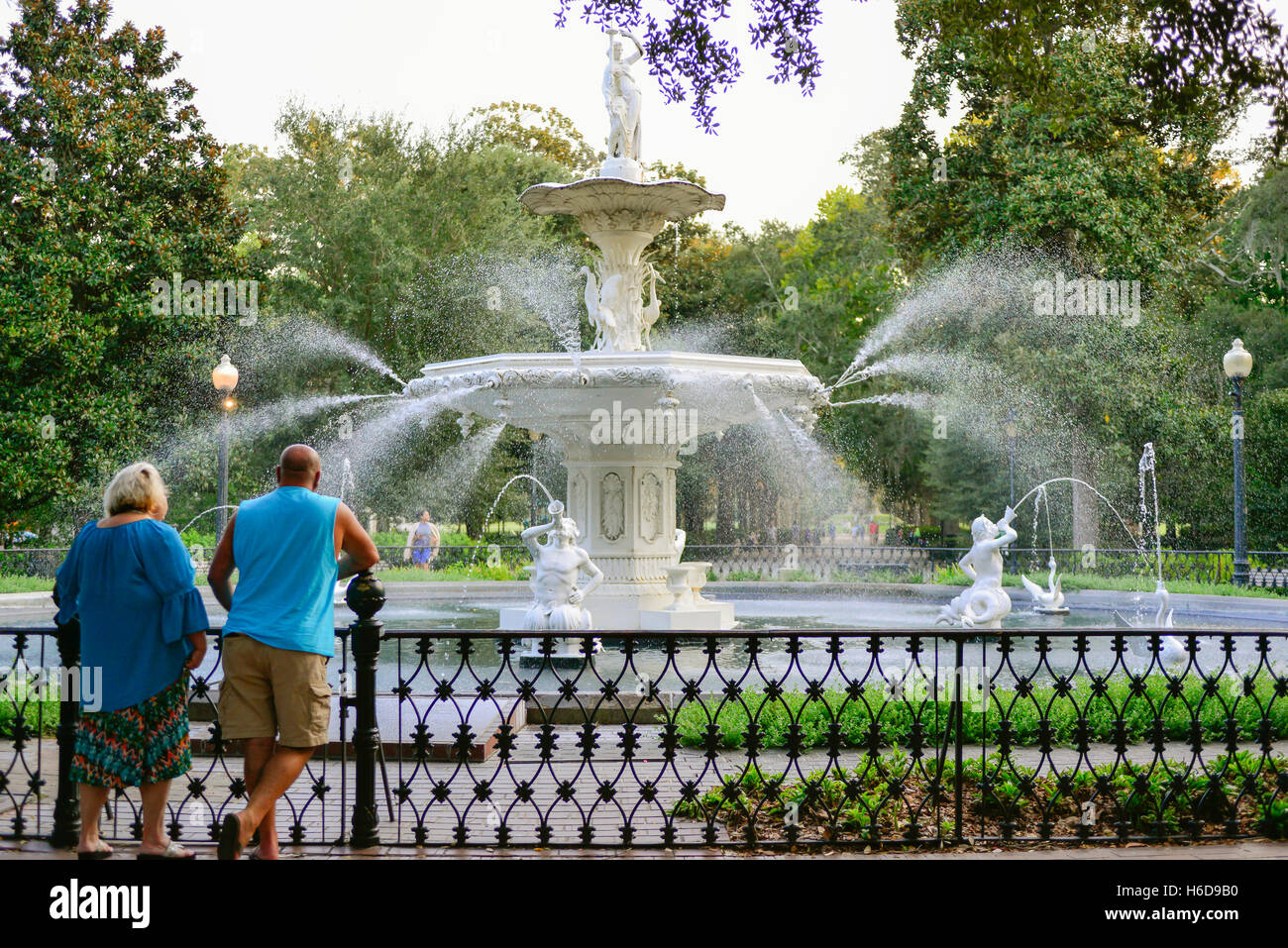 People enjoy & relax around the fanciful landmark fountain in Forsyth Park in historic downtown Savannah, GA Stock Photo