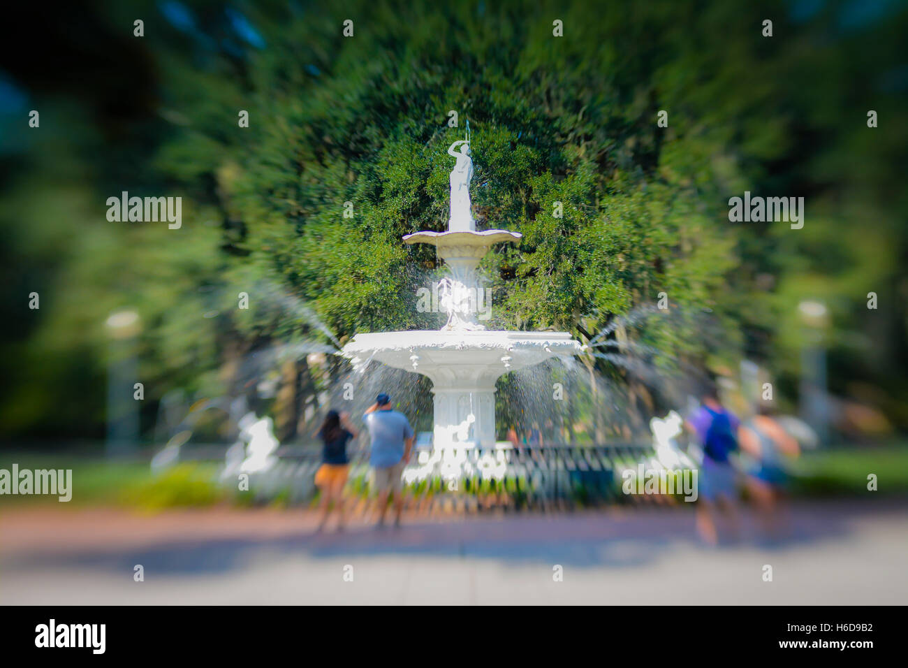 People enjoy & relax around the fanciful landmark fountain in Forsyth Park in historic downtown Savannah, GA Stock Photo