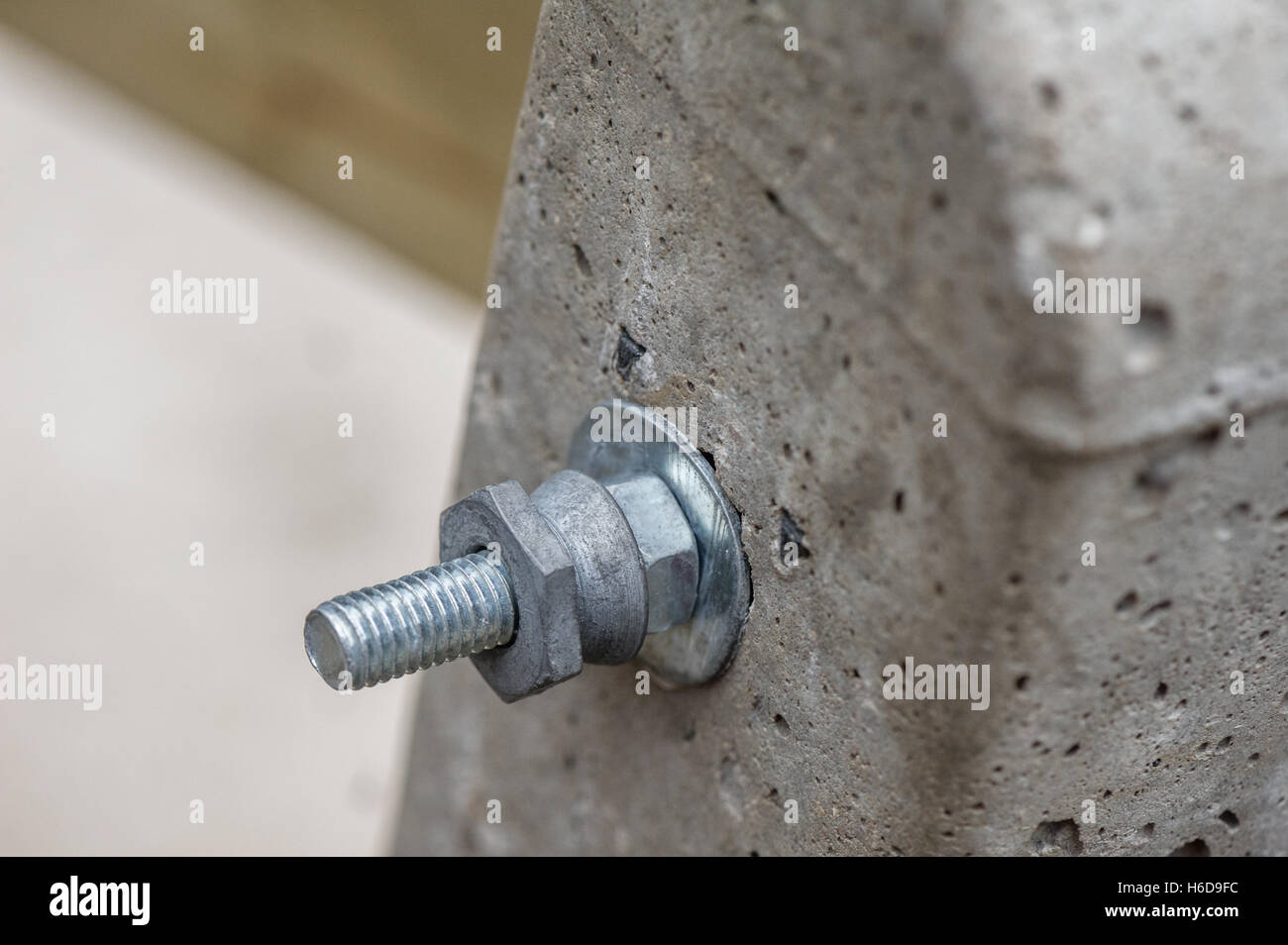 Nut and bolt fixings through a concrete post. Stock Photo