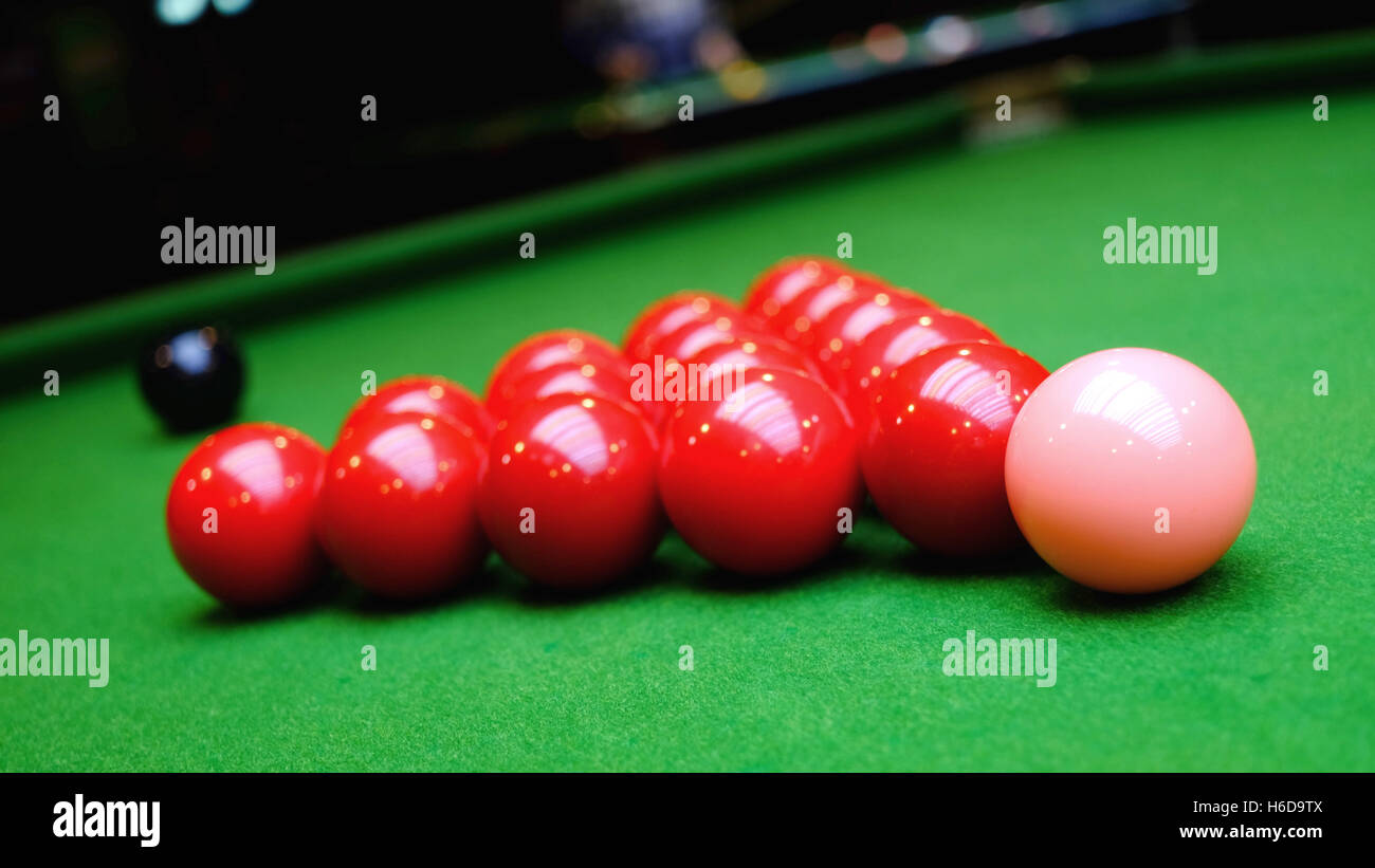 Some red snooker, black and pink balls on green table Stock Photo