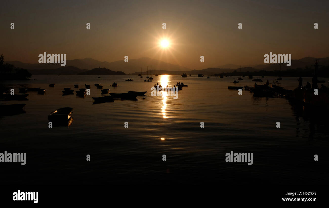 The silhouette of recreational boats, mountain, sun at sunset Stock ...