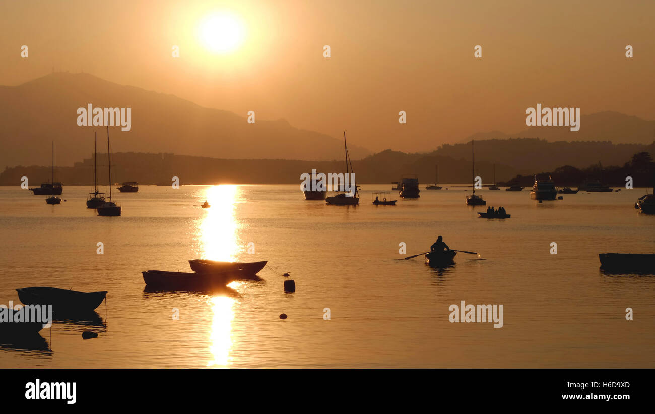 The silhouette of recreational boats, mountain, sun at sunset Stock ...