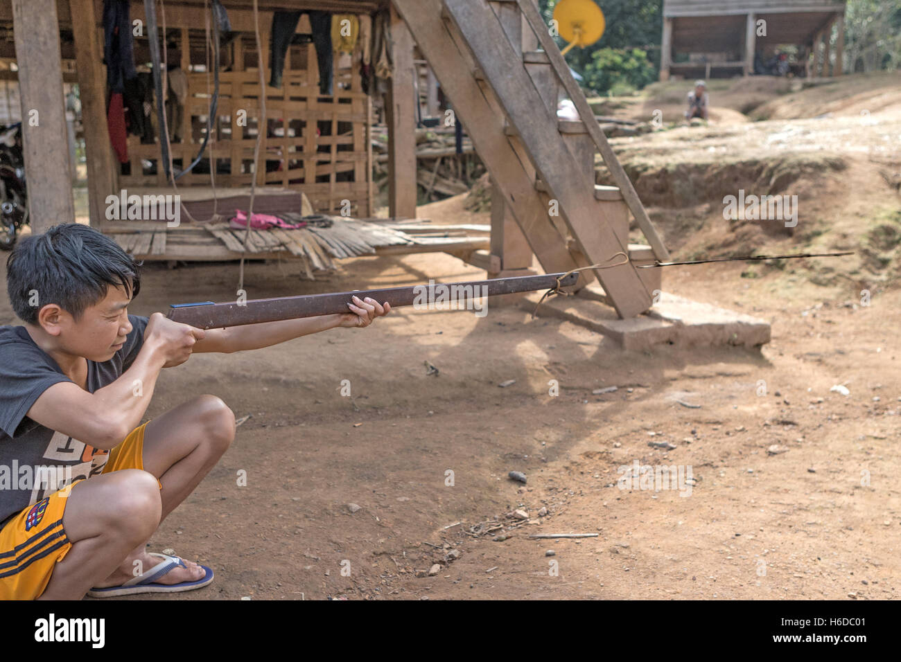 Practise using sling firearm to discharge arrow/bolt squirrel hunting,  Ban Phavie village, Khmu/Khamu people, near Muang La, Oudomxay province, Laos Stock Photo