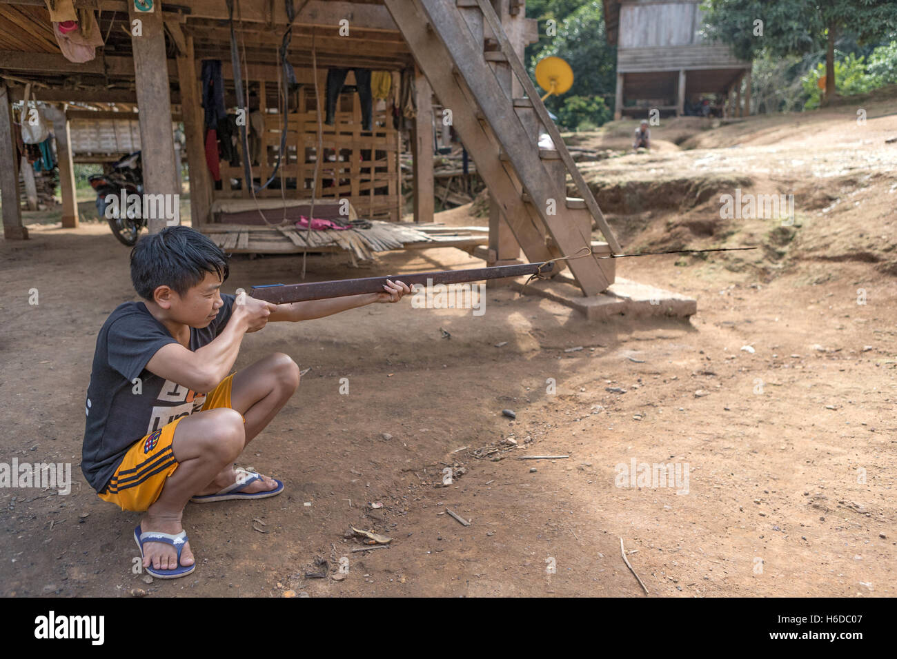 Practise using sling firearm to discharge arrow/bolt squirrel hunting,  Ban Phavie village, Khmu/Khamu people, near Muang La, Oudomxay province, Laos Stock Photo