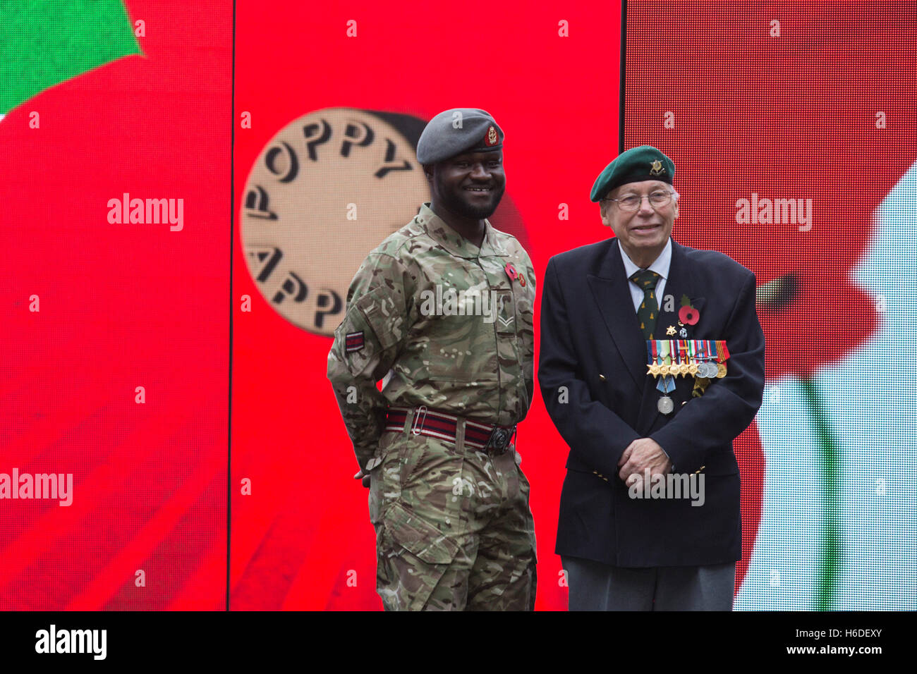 London, UK. 27 October 2016. Pictured: Ben Poku, 34, and Roy Miller, 92. The Royal British Legion’s Poppy Appeal 2016 launches today, Thursday 27 October 2016, with the unveiling of giant video installation in Central London, inviting people to rethink Remembrance. Credit:  Bettina Strenske/Alamy Live News Stock Photo