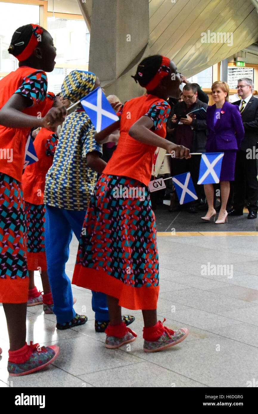 Edinburgh, Scotland, United Kingdom, 27, October, 2016. "The Singing Children of Africa" choir from Kenya, part of the "Educate the Kids" charity, wave saltire flags as they perform in front of First Minister Nicola Sturgeon (R) in the Scottish Parliament, Credit:  Ken Jack / Alamy Live News Stock Photo