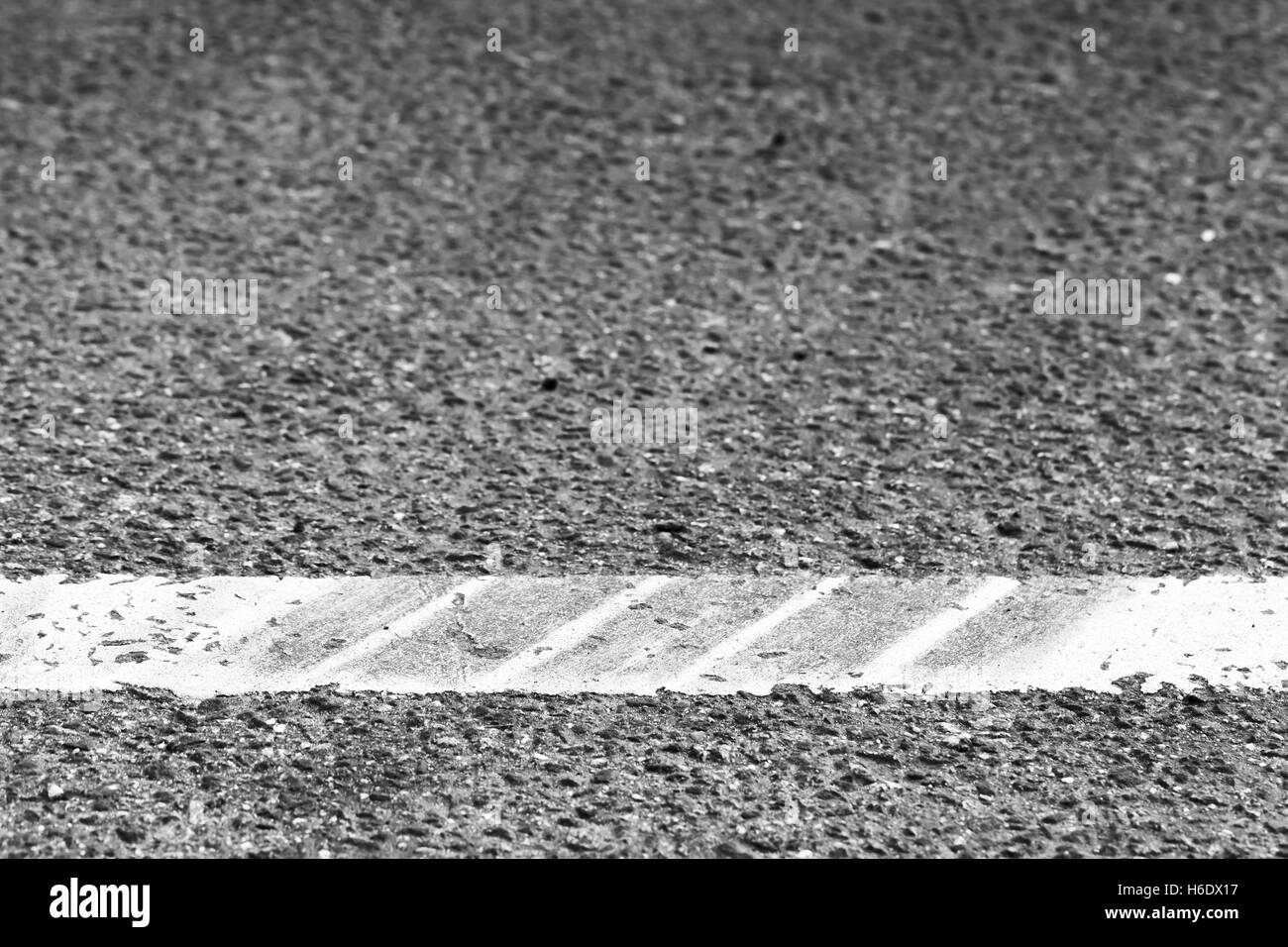 Dividing line with tire tracks over it, highway road marking fragment. Abstract transportation background Stock Photo