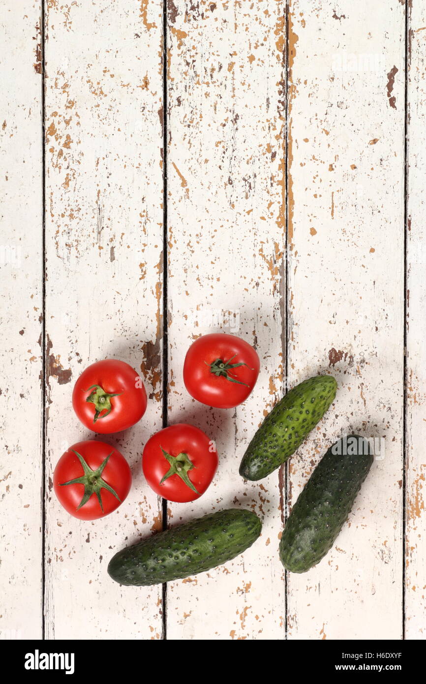 Tomatoes and cucumbers on peeled paint plank background. Directly Above. Stock Photo