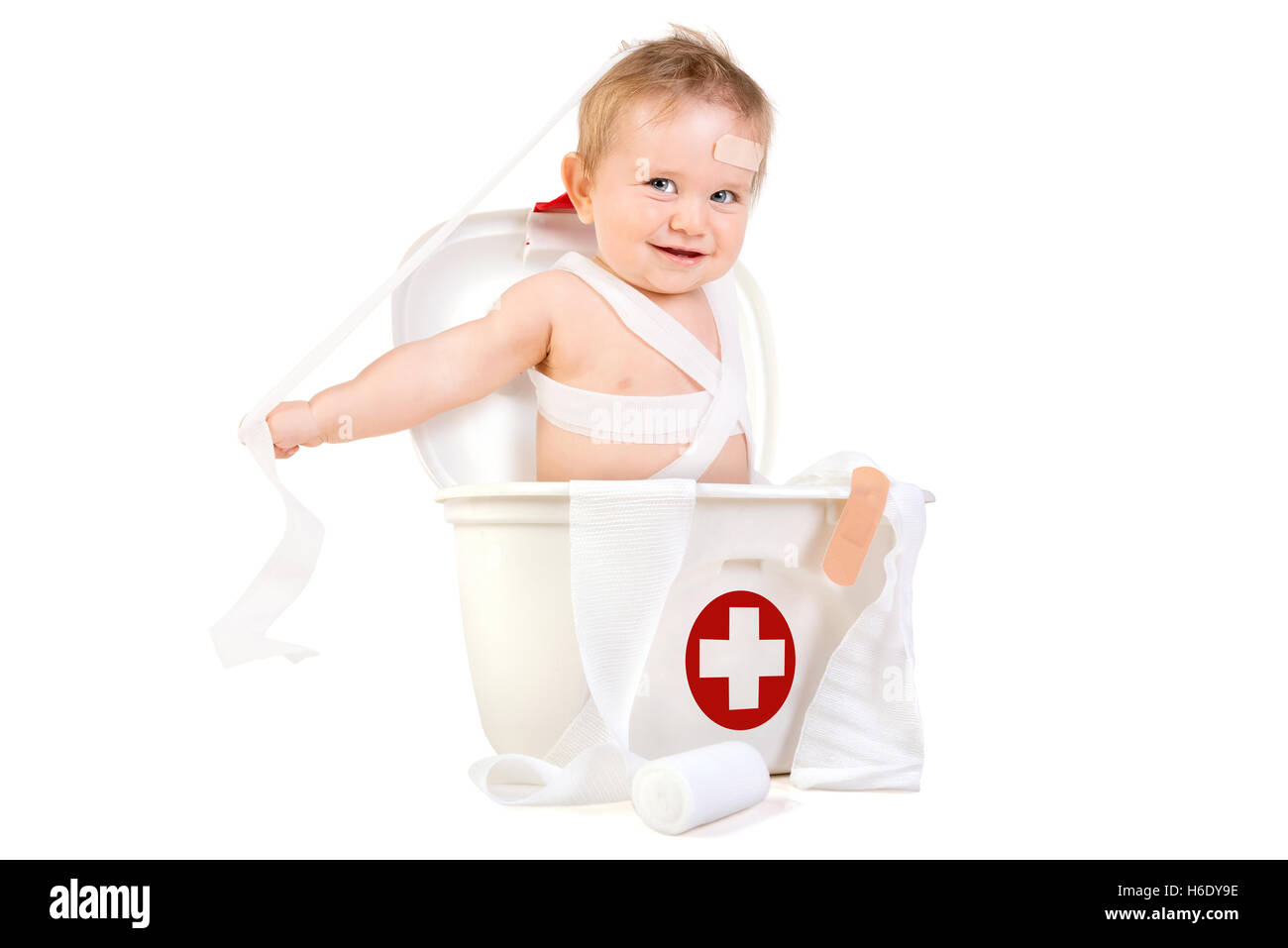 Cute baby boy playing with bandages in a first aid kit box Stock Photo
