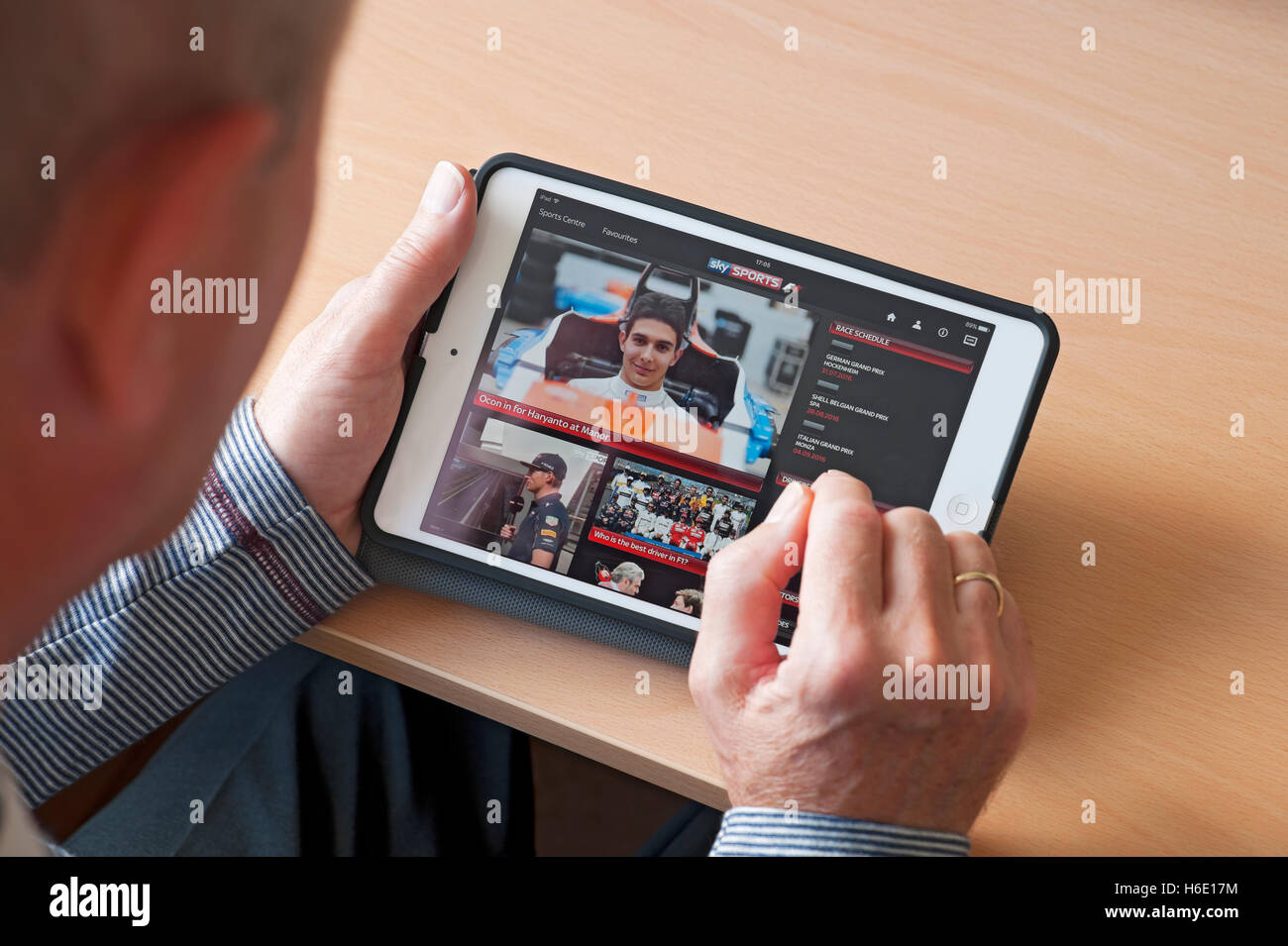 Close up of person man looking at watching Sky Sports app on ipad tablet screen England UK United Kingdom GB Great Britain Stock Photo