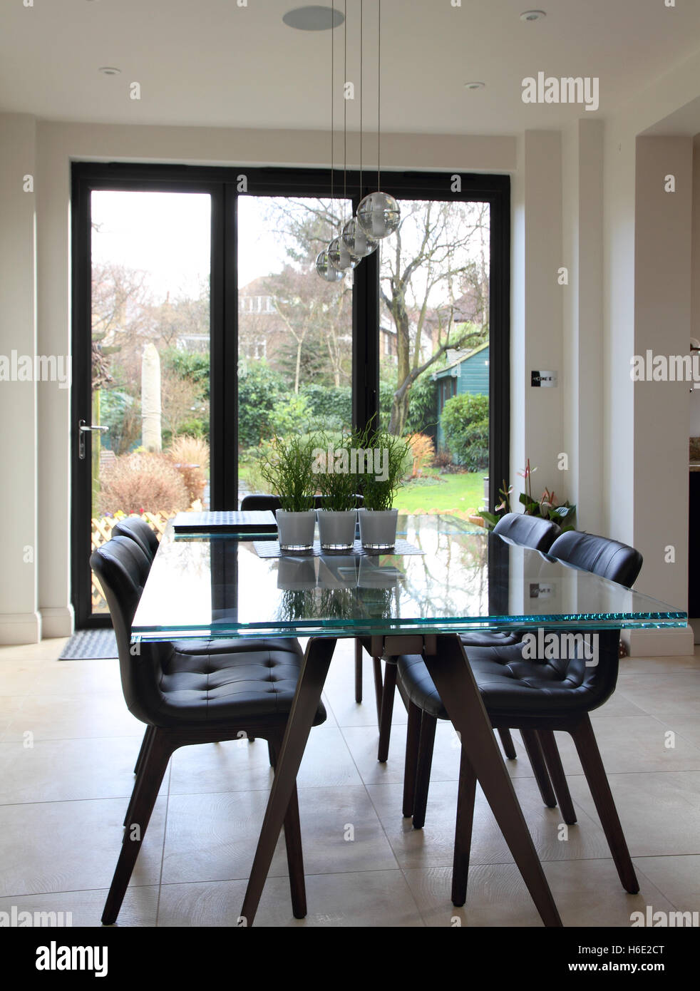 Glass Dining Table With Black Leather Dining Chairs Stock Photo Alamy