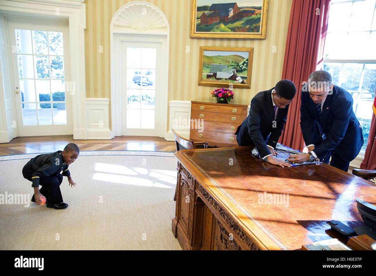 U.S. President Barack Obama signs a poster for 13-year-old student Vidal Chastanet after their Humans of New York blog interview in the White House Oval Office February 5, 2015 in Washington, DC. Stock Photo