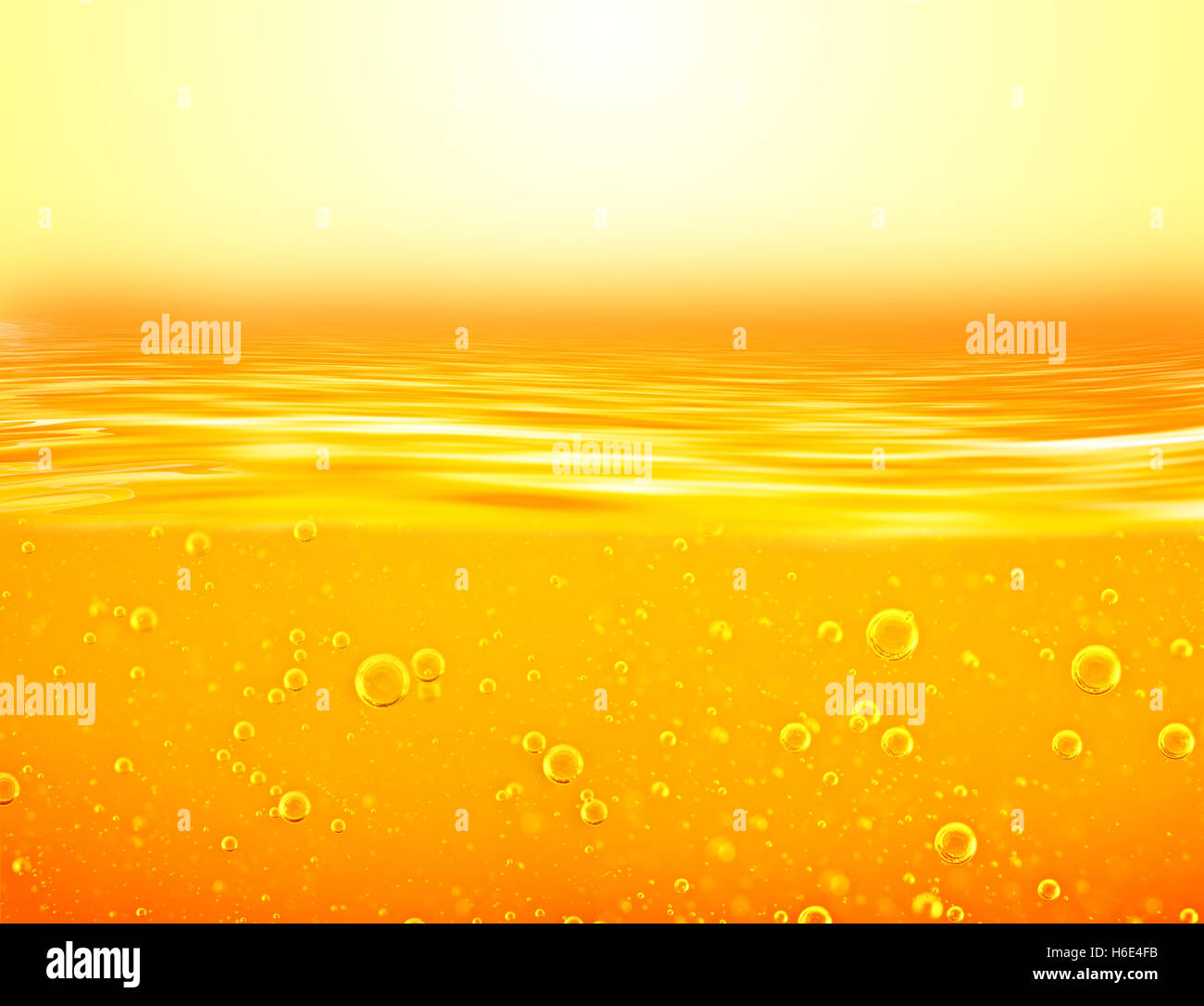 Orange yellow Liquid with oxygen bubbles. Oil. Honey. Beer. Juice. Closeup. Orange yellow waves and sky. Stock Photo