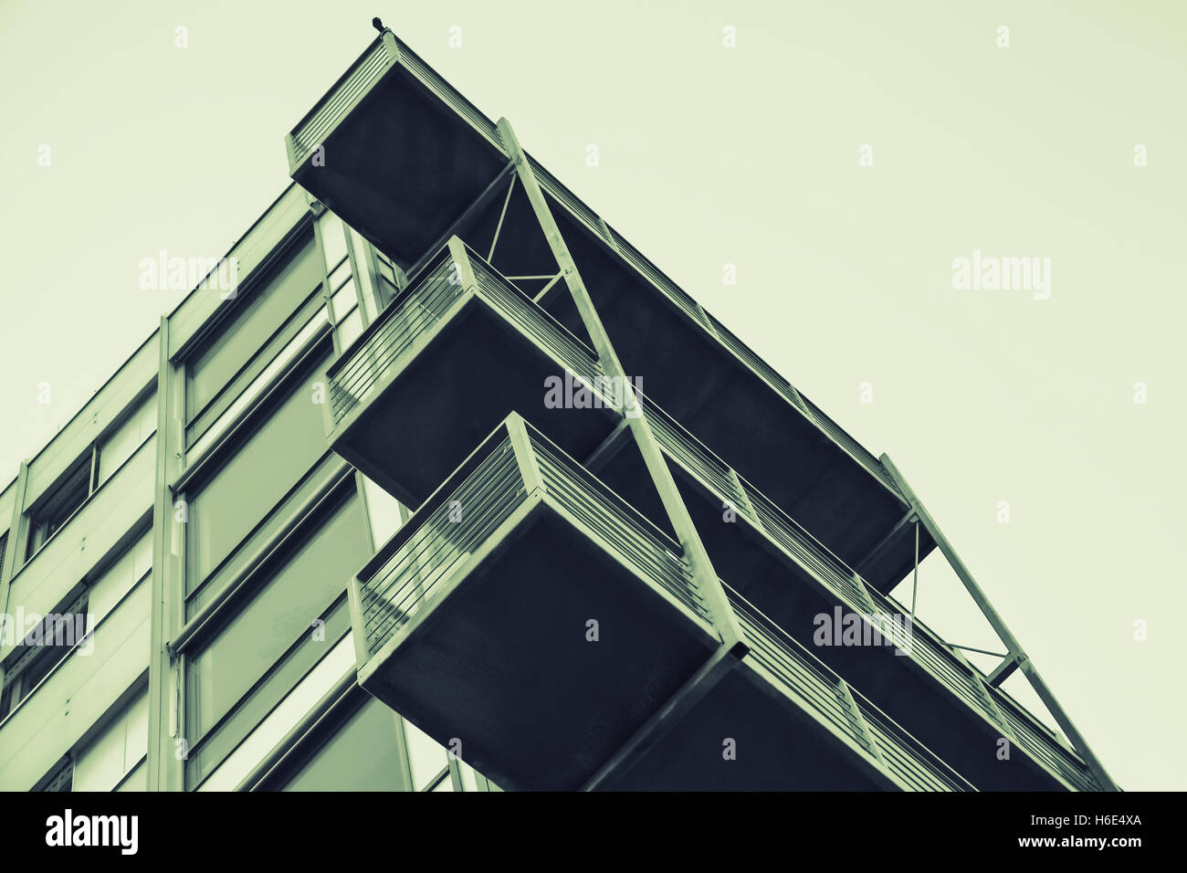Abstract contemporary architecture fragment, walls and balconies made of glass and concrete. Green tonal correction filter effec Stock Photo